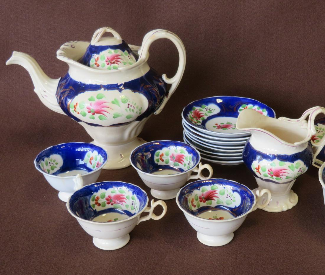 Lusterware tea set with hand painted springs and: Lusterware tea set with hand painted springs and scrolls and cobalt blue background. Includes 1 teapot, 1 creamer, 4 teacups, 8 saucers, and 1 serving plate. All in good condition, mid to late 19th ce