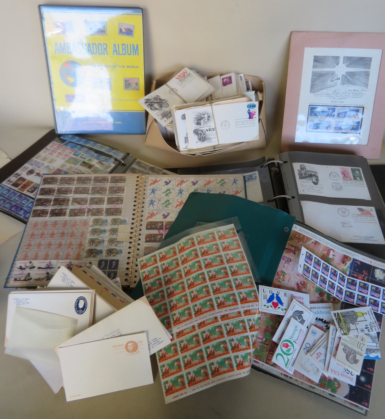 Large grouping of stamps including: Over 100 first day: Large grouping of stamps including: Over 100 first day issues, over $100 face value of unused postage stamps, sheets of canceled stamps, 2 stamp albums with very few stamps, assorted loss stamps, etc