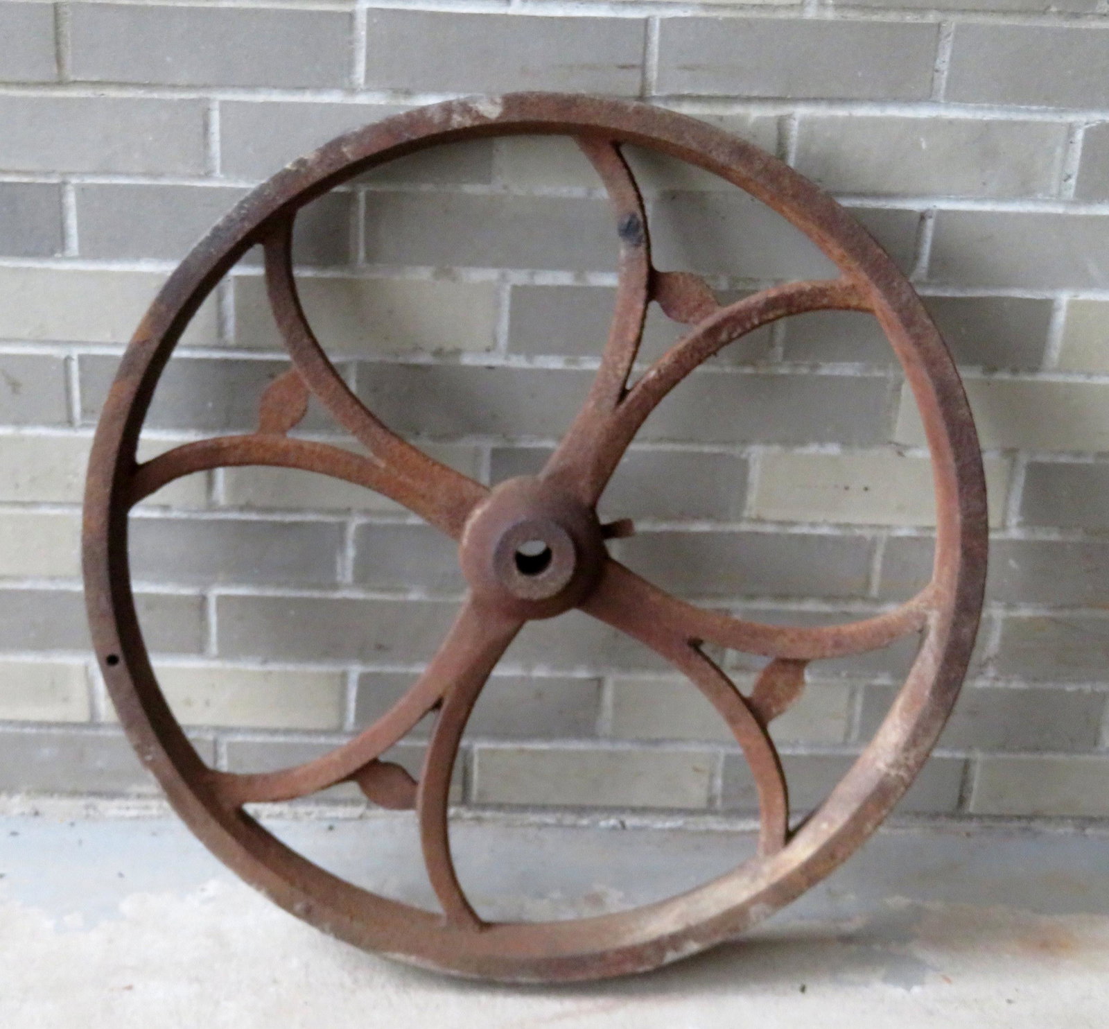 An architectural cast iron wheel. 26"D x 2 3/4"W. Some: An architectural cast iron wheel. 26"D x 2 3/4"W. Some surface rust but overall good condition.