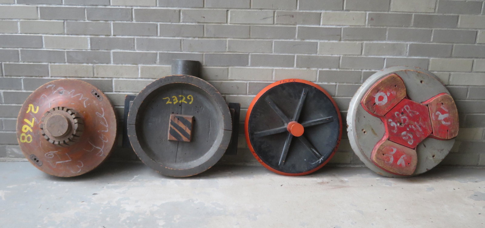 Four industrial wooden foundry molds in the form of: Four industrial wooden foundry molds in the form of wheels - ranging in size from 18 1/2"D to 21 1/2"D - one wheel with slight roughness around edge, otherwise all are in very good condition.
