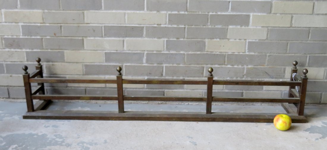 An Arts & Crafts period brass fireplace fender with: An Arts & Crafts period brass fireplace fender with ball finials, early 20th century - one finial with small dings, else very good condition. 52 3/4"W x 9 1/2"D x 10 5/8"H.