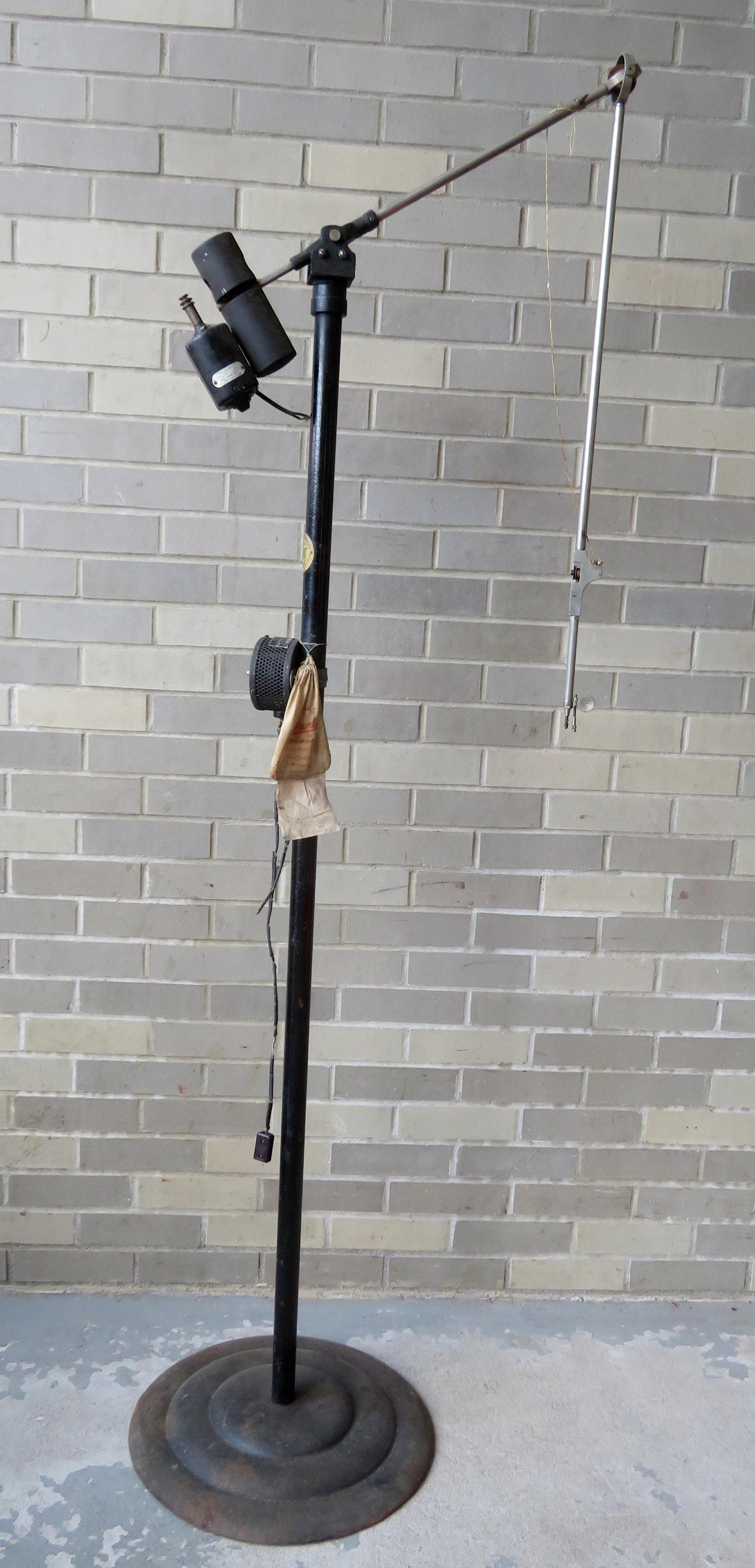 An unusual standup counter balance sewing machine with: An unusual standup counter balance sewing machine with a central post having an extendable arm that performs the sewing operation when held by the operator - 57"H. The rod is attached to a circular ba