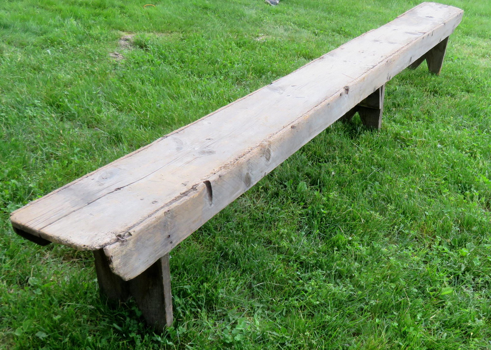 Long primitive 19th century wooden bench, square nail: Long primitive 19th century wooden bench, square nail construction, boot jack ends - weathered and minor losses (see photos). Size 11' 1 1/2"L x 11"W x 16 1/2"H.