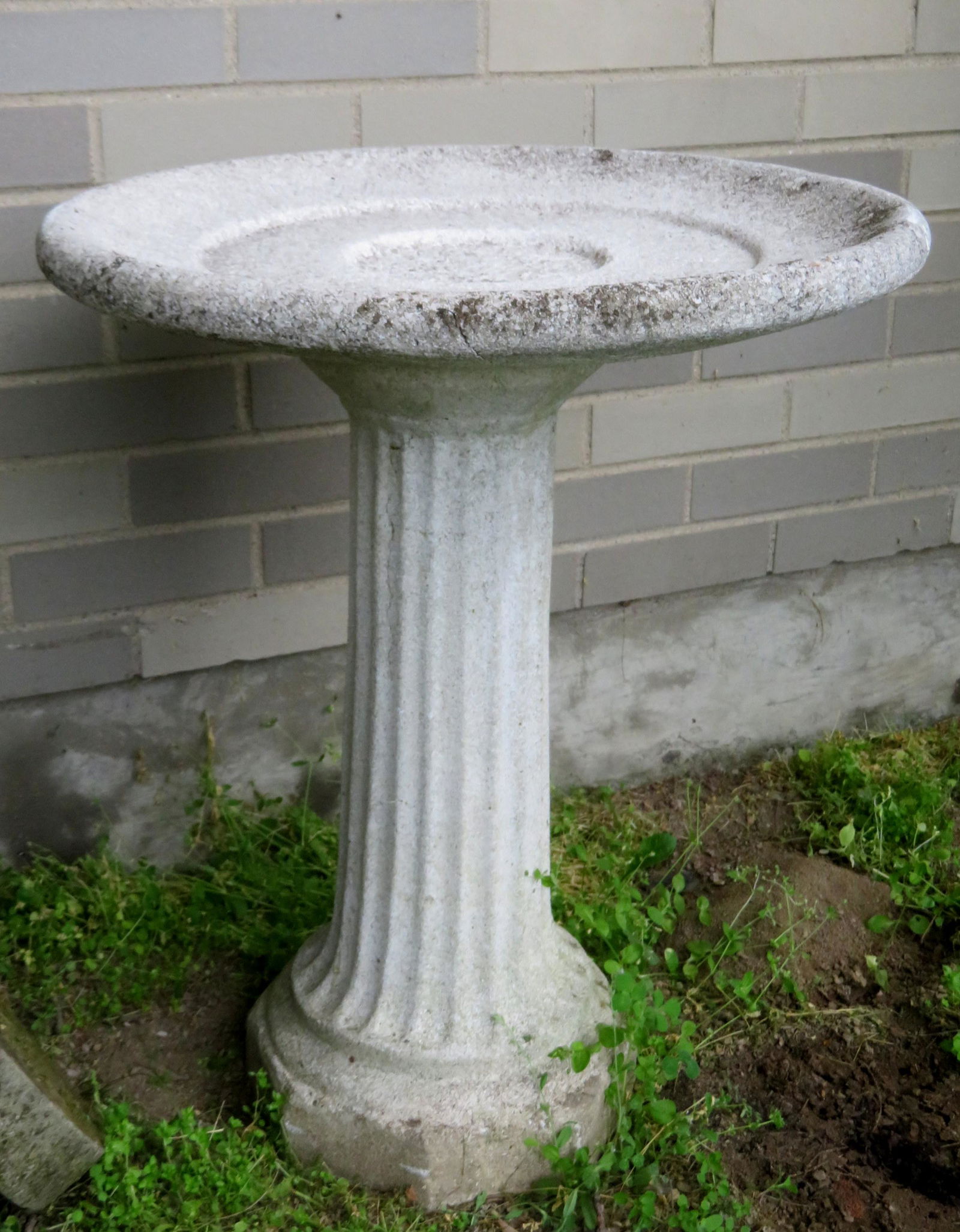 Cast stone bird bath on fluted column, circa 1950.: Cast stone bird bath on fluted column, circa 1950. Spider hairline extending from rim, but structurally sound and in good condition. Probably mid 20th century. 21 1/4"dia. x 26 3/4"H.