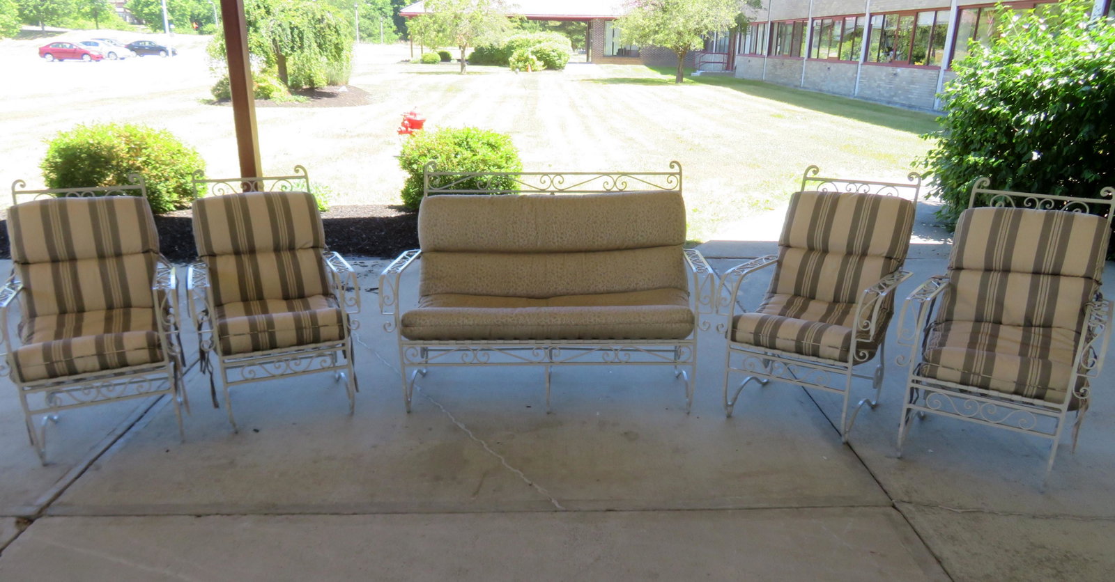 A wrought iron patio set consisting of 4 high quality: A wrought iron patio set consisting of 4 high quality chairs and a matching settee, all with sheet iron slats on seat and backs, circa 1960. Professionally repainted with newer custom cushions. Kept i