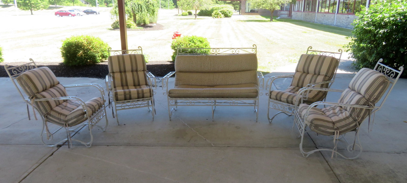 A wrought iron patio set consisting of 4 high quality: A wrought iron patio set consisting of 4 high quality chairs and a matching settee, all with sheet iron slats on seat and backs, circa 1960. Professionally repainted with newer custom cushions. Kept i