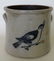 A stoneware crock decorated with a cobalt blue bird on