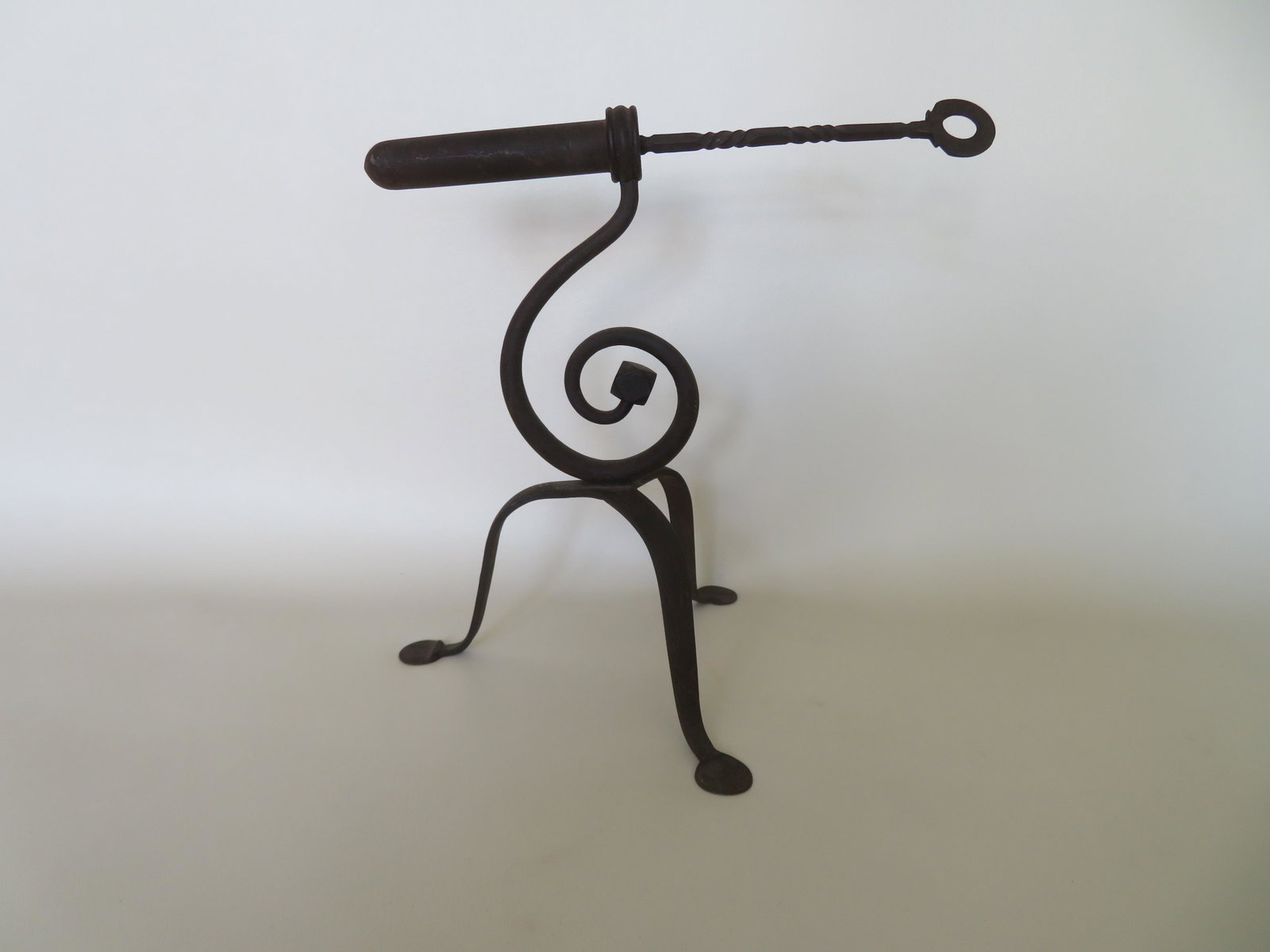 Queen Ann hand forged goffering iron with a scrolled: Queen Ann hand forged goffering iron with a scrolled support with a multi-faceted iron terminal, mounted on a tripod base with penny feet, original poker with spiral handle with incised decorations, 1