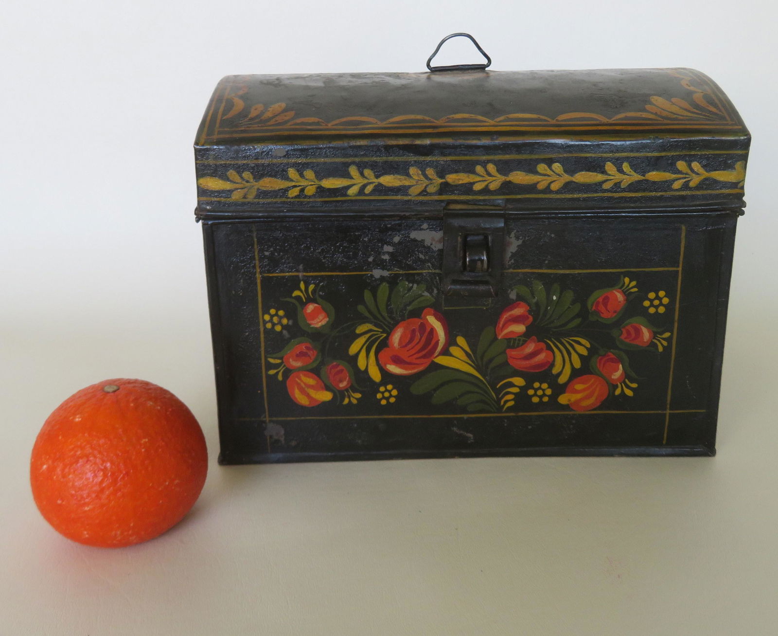 A toleware box, 19th century. The lid decorated with: A toleware box, 19th century. The lid decorated with wavy lines around the perimeter and the front and sides decorated with flowers. Paint touchup, but overall good condition. 10"W x 6 1/2"D x 7 1/4"H