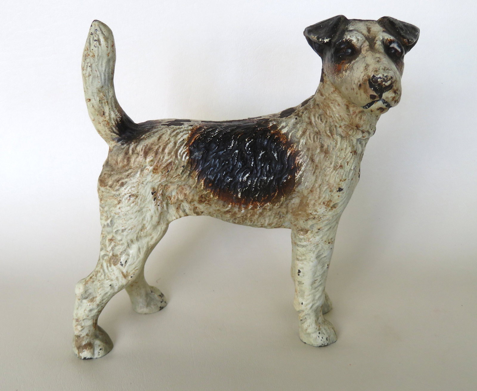 Cast iron Fox Terrier dog door stop in original paint,: Cast iron Fox Terrier dog door stop in original paint, late 19th century. Very good condition. 8"H x 8 1/4"W.