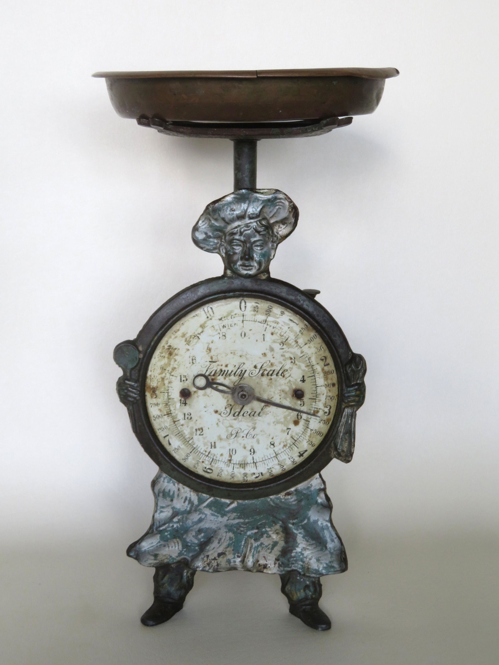 A baker man figural dial scale in cast iron with: A baker man figural dial scale in cast iron with removable brass tray marked "Family Scale - Ideal - P Co.". The back side with incised Art Nouveau style flowers including tulip. Note the heart shaped
