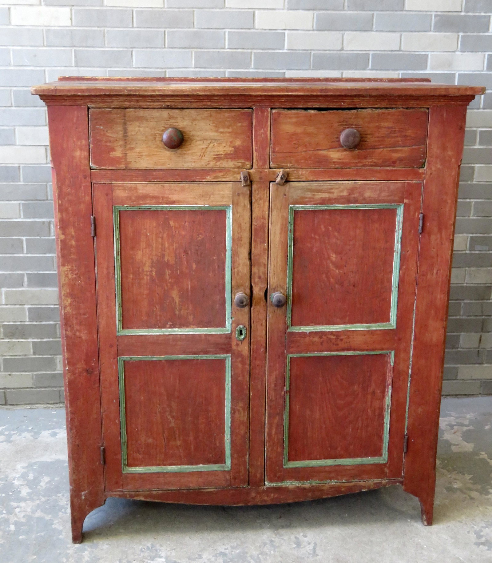 Well built early painted jelly cupboard on high cutout: Well built early painted jelly cupboard on high cutout base, having 2 beaded drawers over 2 beaded and paneled doors, front edge with stopped chamfers, scraped down to original red paint, square nail 