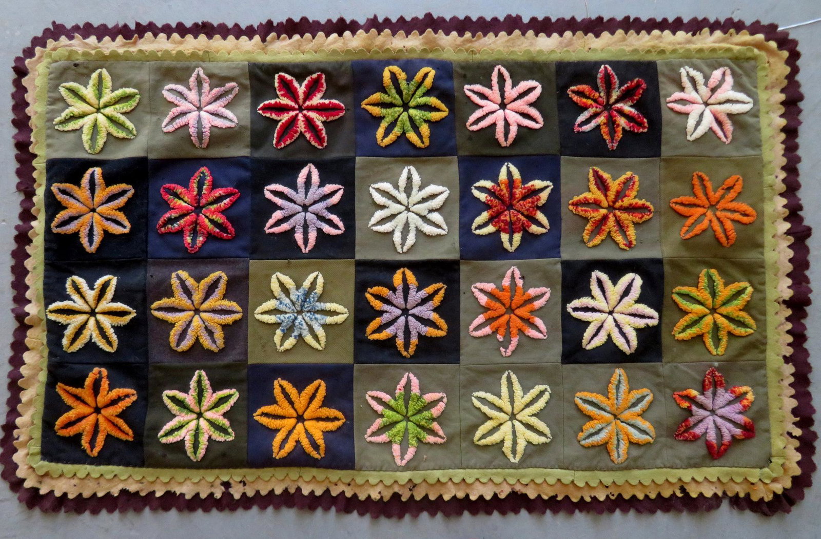 A wool and felt stumpwork embroidered table rug: A wool and felt stumpwork embroidered table rug decorated with colorful flowers, 19th century. Minor wool tears/holes in felt, losses to the burlap backing, but overall good condition. 45" x 28". Prov
