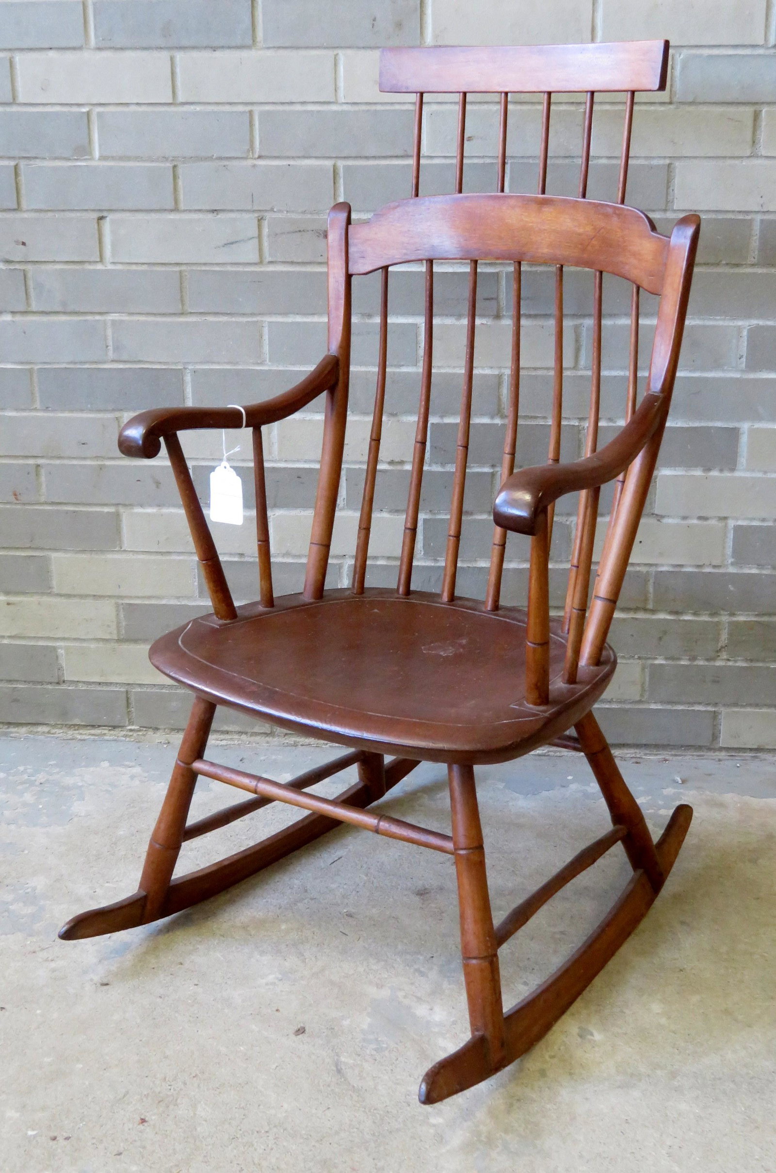 A comb-back Windsor rocker with saddle seat, scrolled: A comb-back Windsor rocker with saddle seat, scrolled arms, and 7 spindle back, late 18th to early 19th century. Very good condition.
