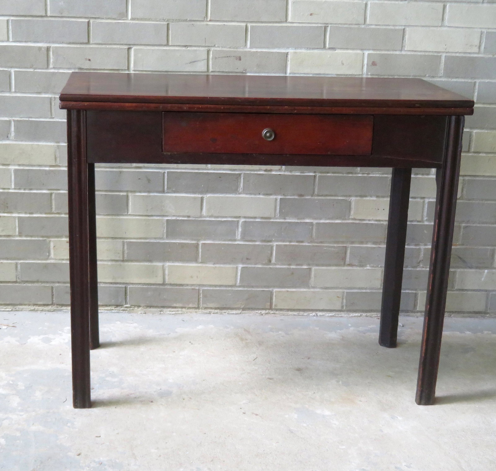 An American Chippendale cherry game table with: An American Chippendale cherry game table with Marlborough legs (one swing leg) and center drawer. Condition - small spliced repair on interior of top as well as expansion crack - some surface wear to