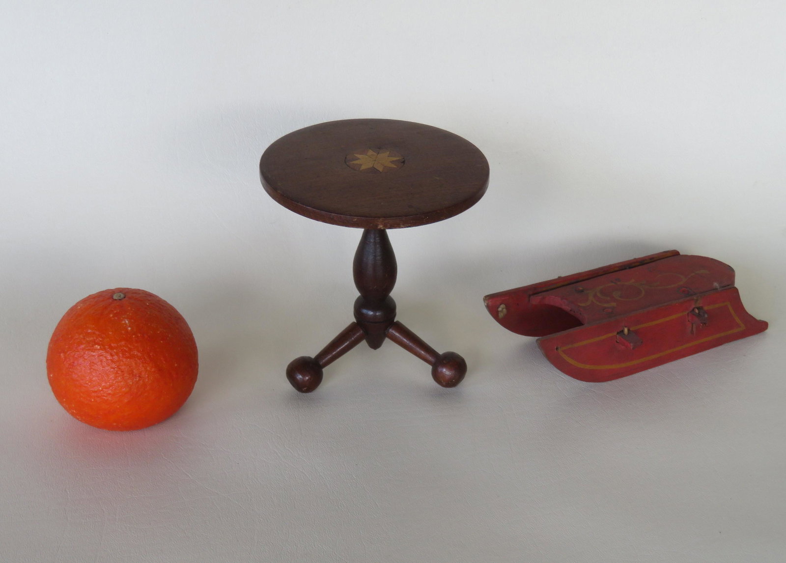 Two miniature hand made objects: A folkart tea table: Two miniature hand made objects: A folkart tea table having a top with an inlaid star over a turned column leading to a tripod base with ball feet - original finish - 19th century - 5"H x 4 5/8"D (top