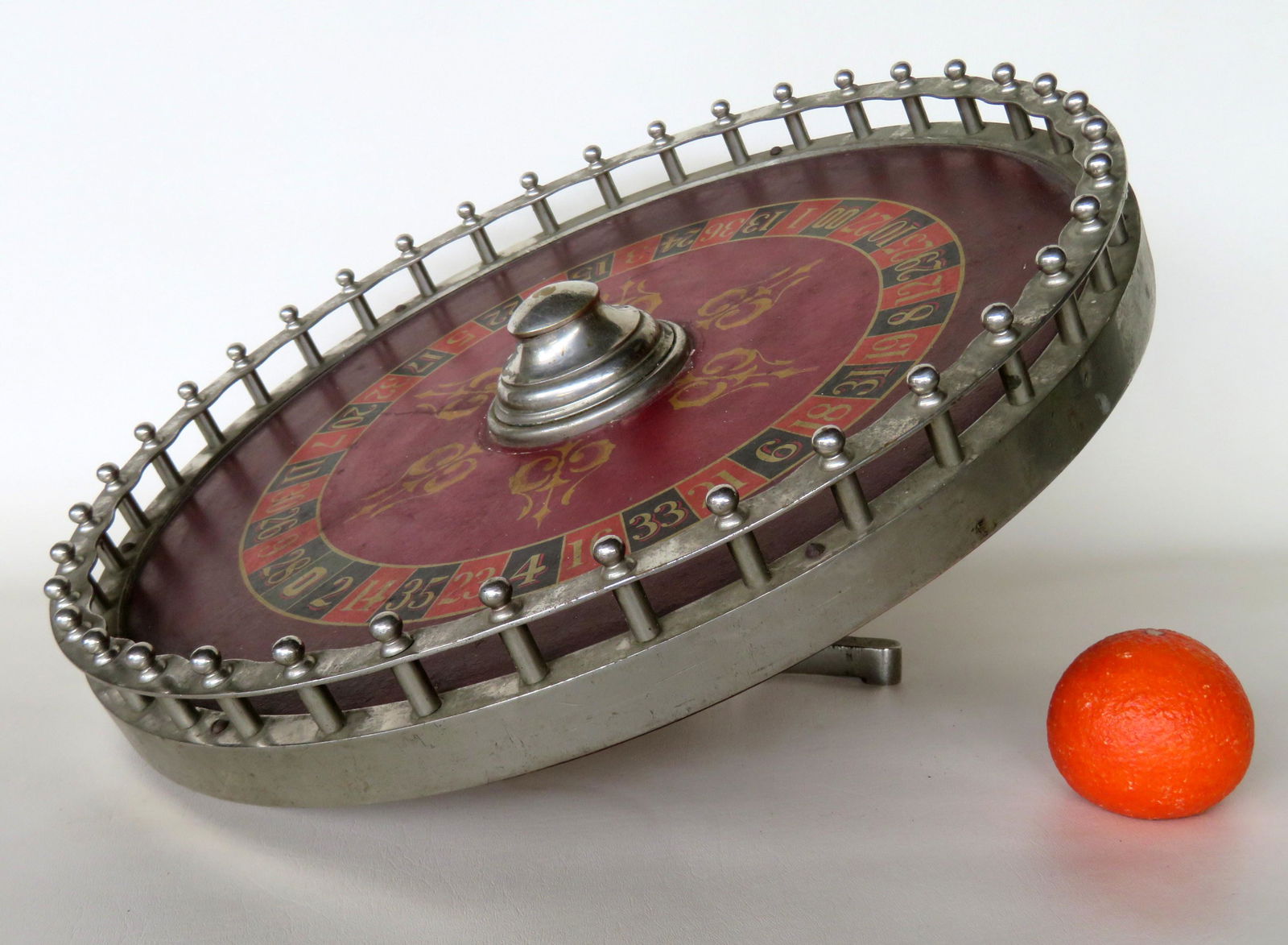 An unusual stenciled table top roulette wheel on tilted: An unusual stenciled table top roulette wheel on tilted stand having a nickel plated fenced border, late 19th to early 20th century. Very good condition in working order. 20"D x 12"H. The wheel is rem