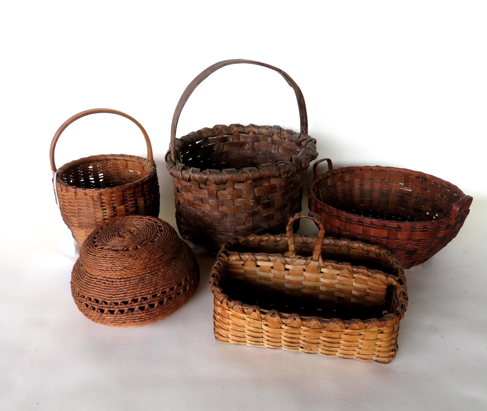 Grouping of 5 vintage baskets including: A good divided: Grouping of 5 vintage baskets including: A good divided berry basket with single loop central handle with berry stains and in very good condition - 11"W x 9"D x 6 1/2"H; 2 Native American with colored