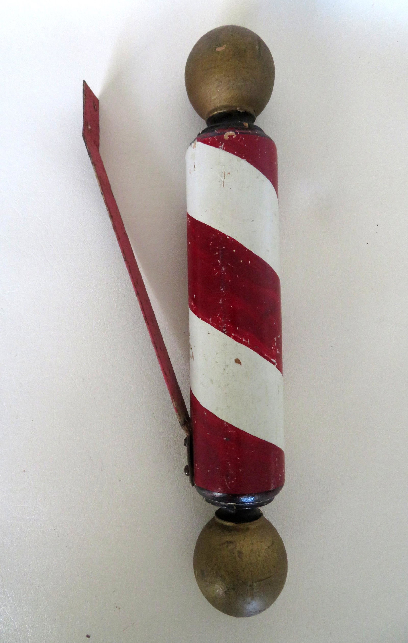 A small barber's pole having a column in original red: A small barber's pole having a column in original red and white paint and each terminal decorated with gold ball shaped finials - note that between the ball and the column there is a small turning tha