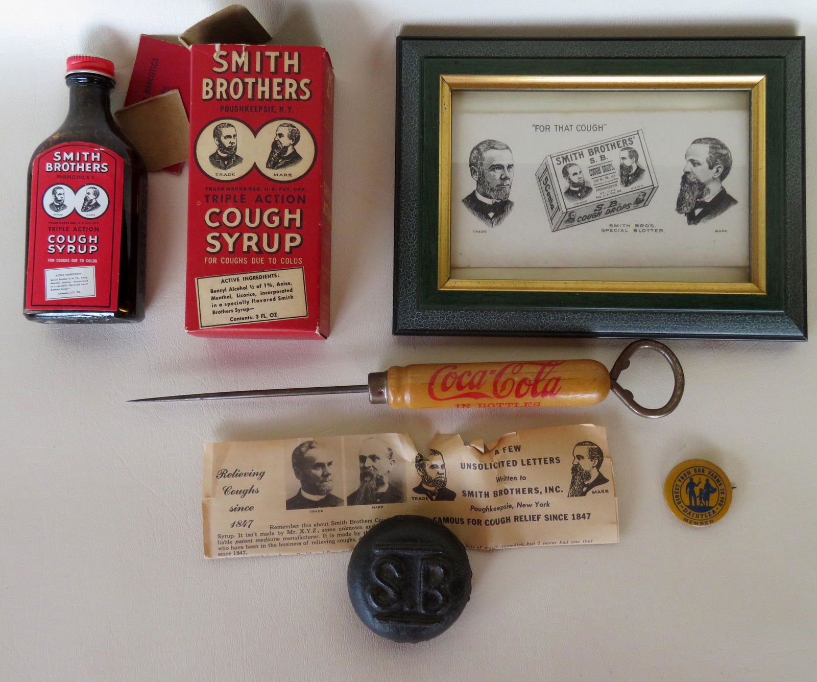 Grouping of 5 advertising articles including a Coca: Grouping of 5 advertising articles including a Coca Cola ice pick, a Smith Brothers paperweight, an unused Smith Brothers cough syrup bottle with instructions in original box (the box with tear and br