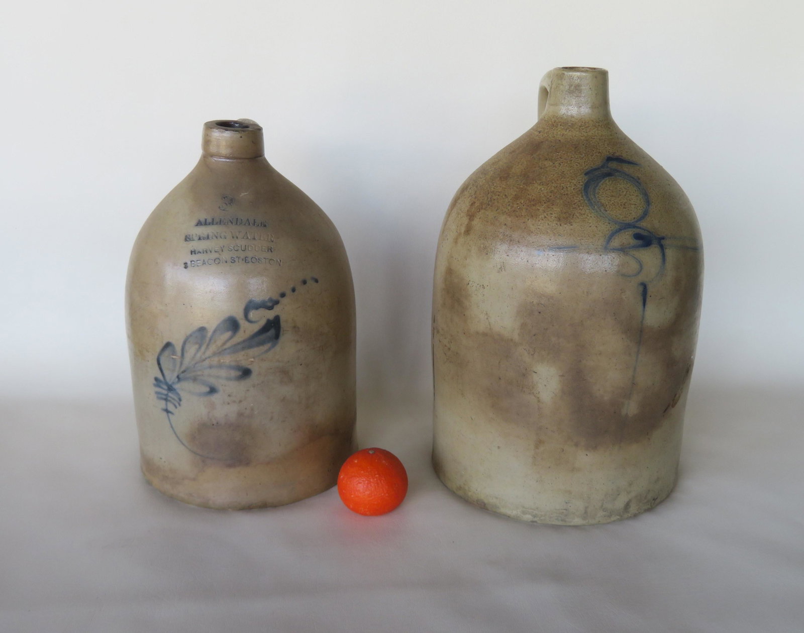 Two stoneware jugs including: The first decorated an: Two stoneware jugs including: The first decorated an advertising 3 gallon jug, decorated with cobalt blue leaves, stamped "Allendale Spring Water / Harvey Scudder / 3 Beacon St. Boston" - several tiny