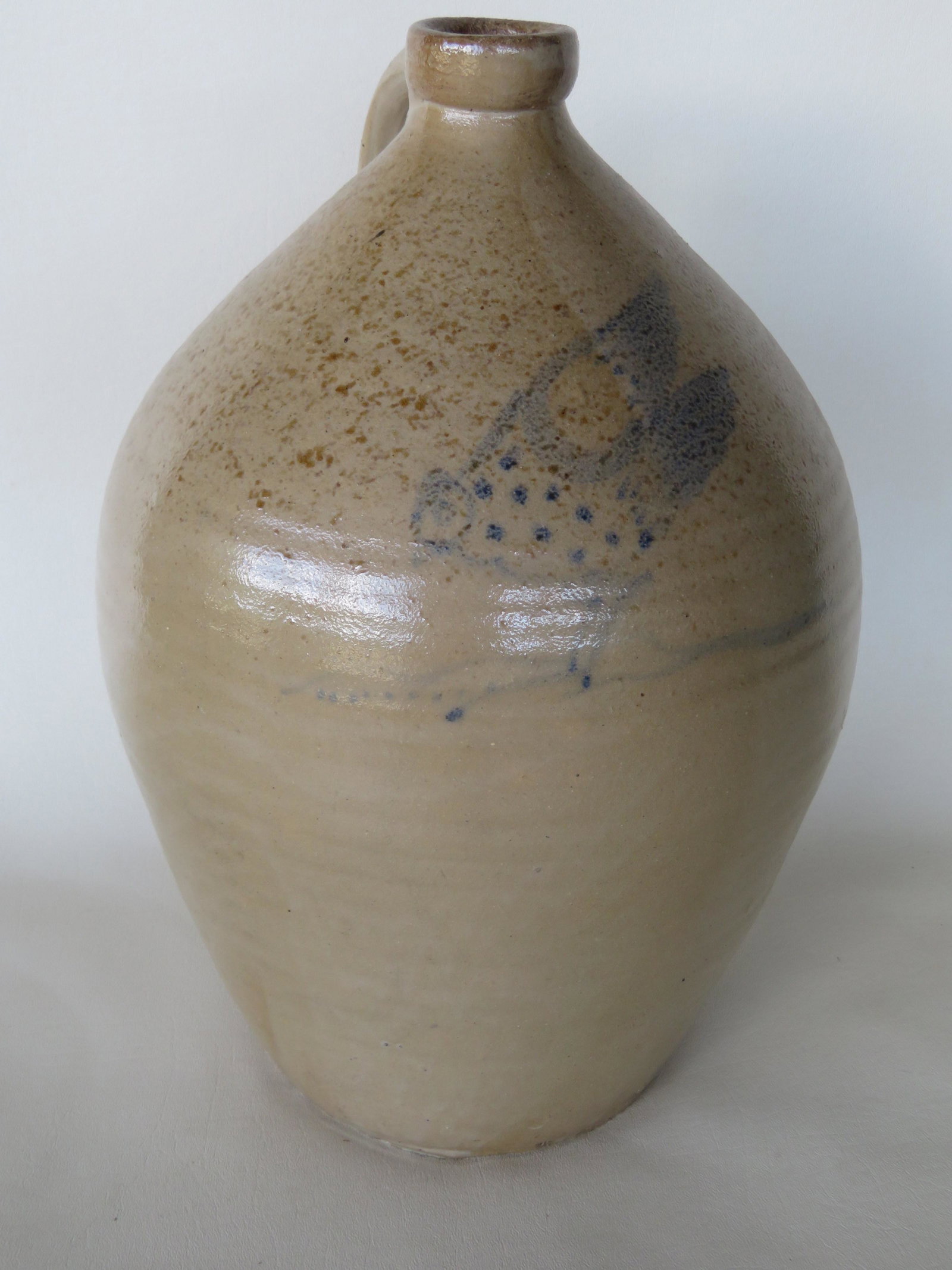 Stoneware ovoid jug, probably 3 gallon size, decorated: Stoneware ovoid jug, probably 3 gallon size, decorated in cobalt blue with a folky chicken with extended wings pecking at corn. The image is lightly painted in blue but no damage to crock which is in 