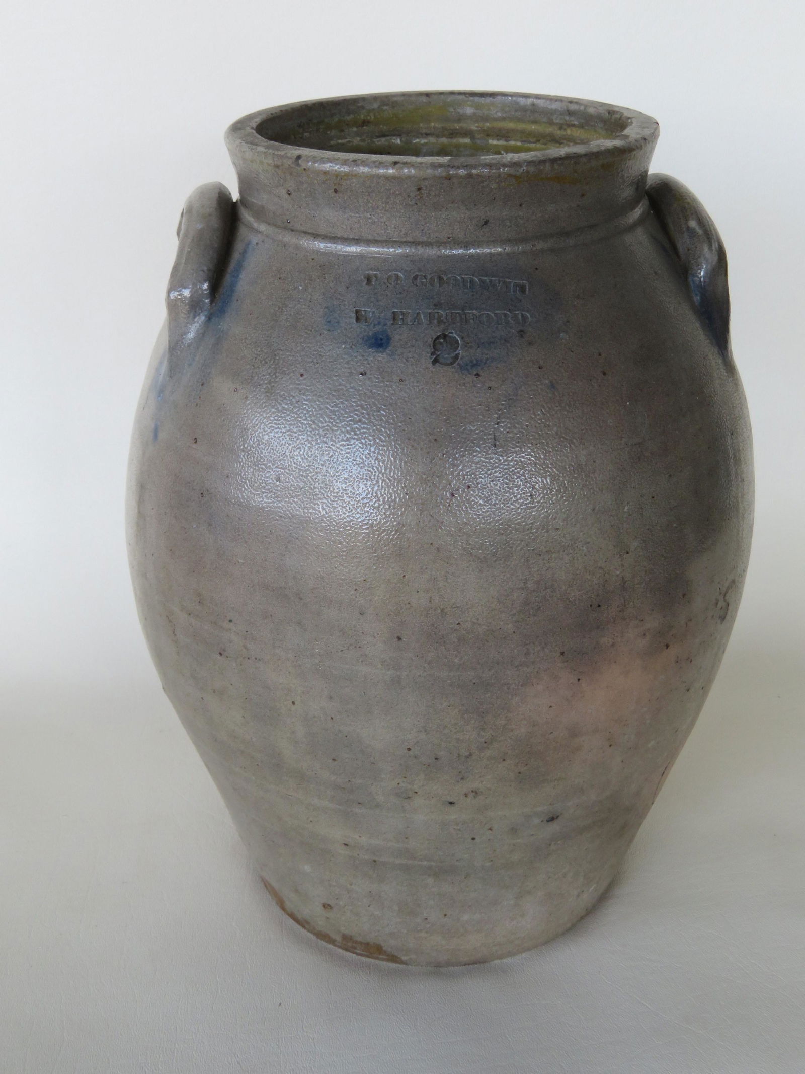 Stoneware ovoid crock, 2 gallon, with impressed mark of: Stoneware ovoid crock, 2 gallon, with impressed mark of "T O Goodwin W. Hartford" (Thomas O'Hara Goodwin, circa 1830). Tooled shoulder and the ears with brushed cobalt blue. Some staining, 1 small chi