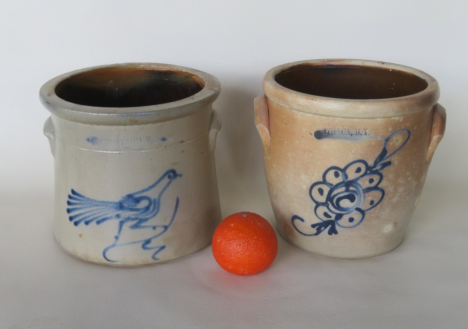 Two NY stoneware crocks including: Impressed mark of: Two NY stoneware crocks including: Impressed mark of "Whites Utica N", 1 gallon, decorated with cobalt blue bird on branch - 2 hairline cracks, stain on reverse side; and impressed mark of "Ithaca, N.