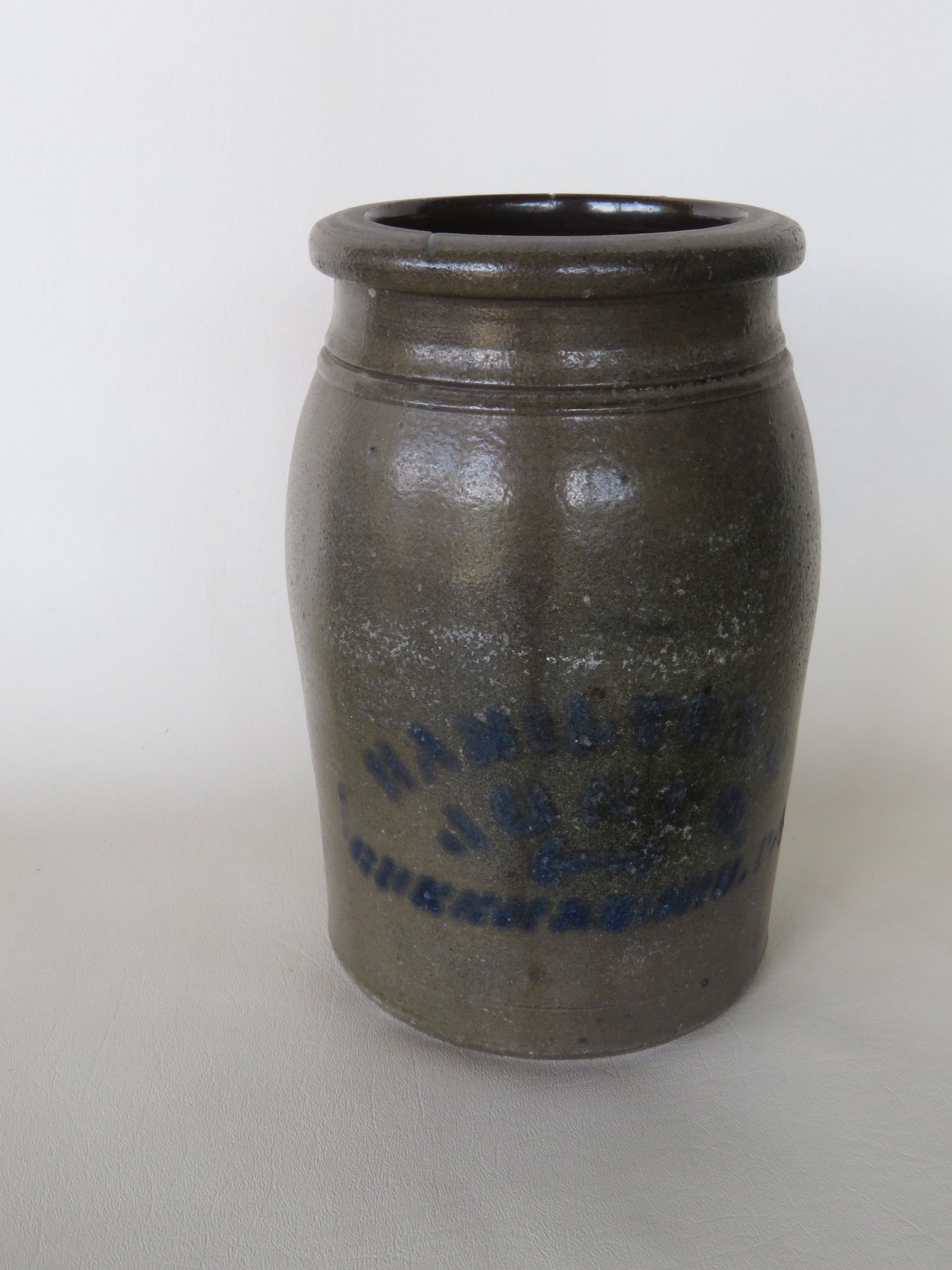 Stoneware pantry jar signed in blue "Hamilton & Jones /: Stoneware pantry jar signed in blue "Hamilton & Jones / Greensboro Pa."- semi-rounded lip over tooled shoulder. Tight hairline on side extending from rim approximately 5 1/2". Total height of jar 9 7/