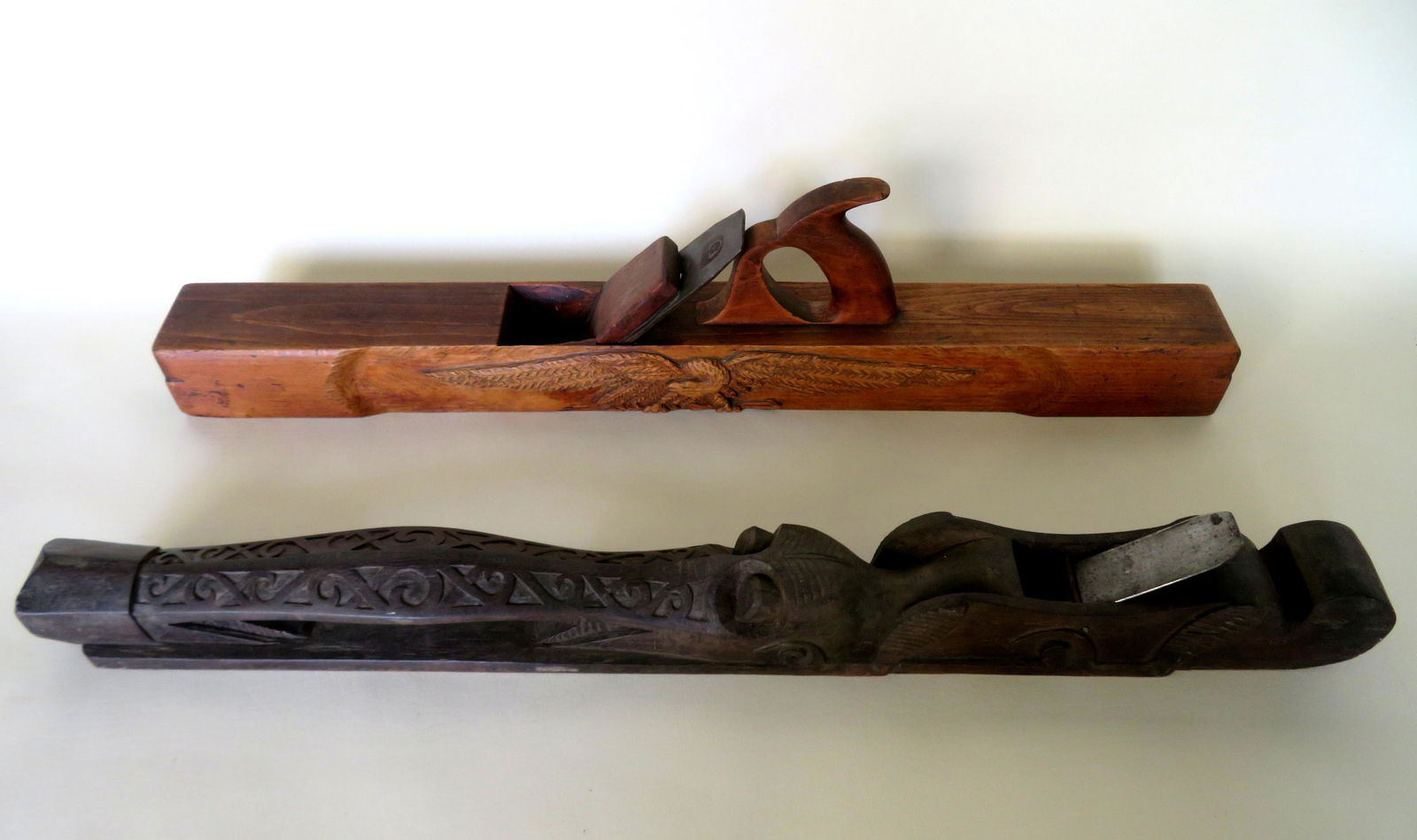 Two unusual jack planes including: One in figural ebony: Two unusual jack planes including: One in figural ebony in the form of a stylized alligator, probably African, 19th century - very good condition - 31"L 2 3/4"W x 3"H; and one in maple having an image