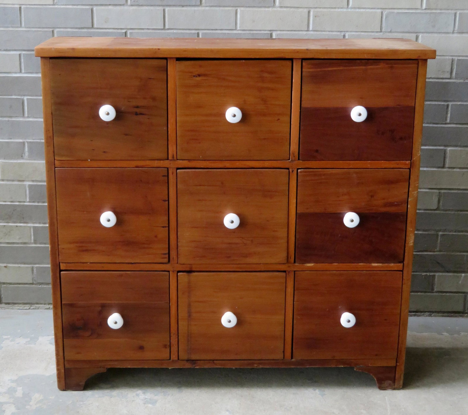 An apothecary cabinet having 9 drawers with porcelain: An apothecary cabinet having 9 drawers with porcelain pulls. Refinished and in very good condition. Probably late 19th to early 20th century. 37"W x 11 3/4"D x 35 3/4"H.