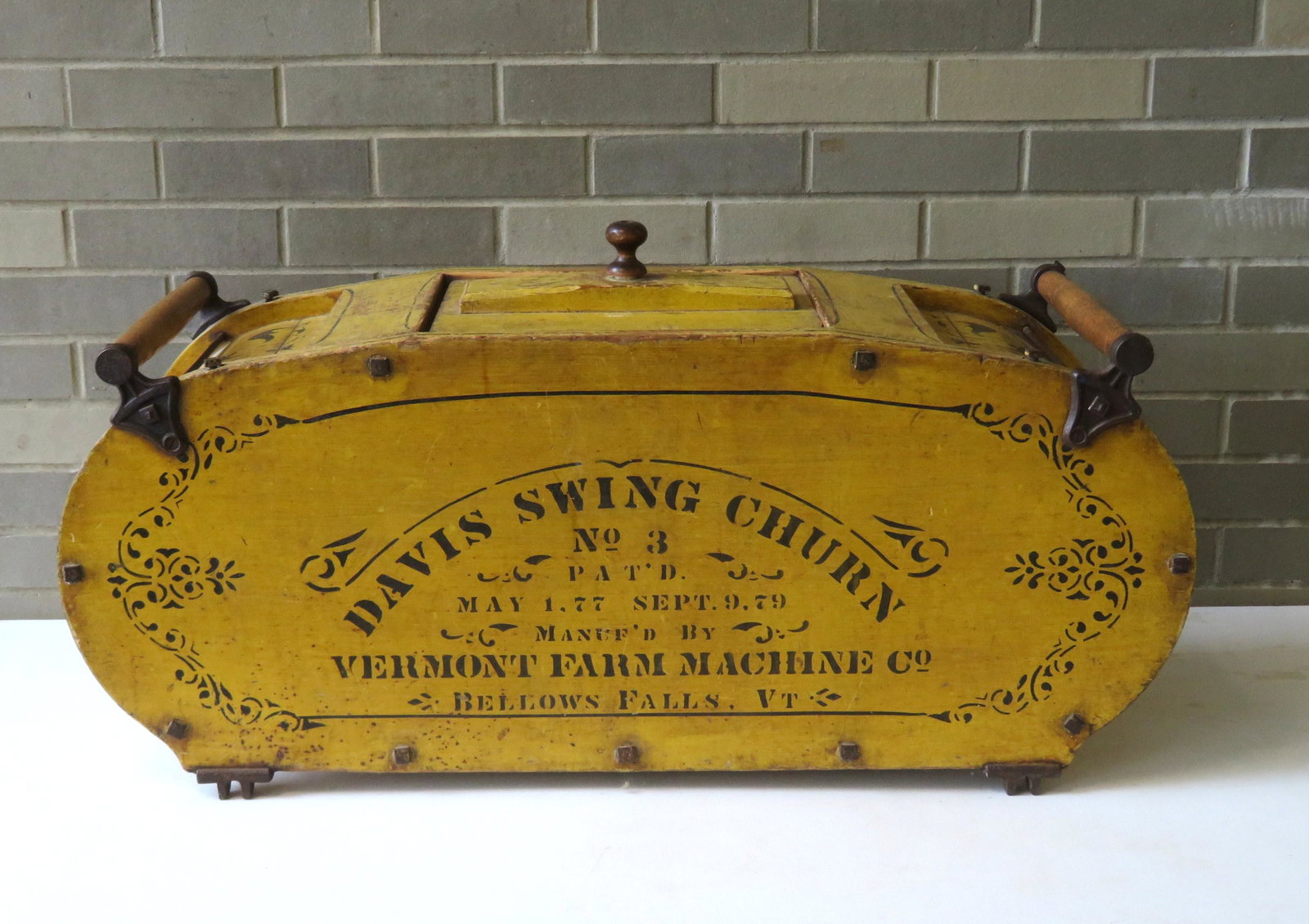 A cradle butter churn stenciled on yellow ground "Davis: A cradle butter churn stenciled on yellow ground "Davis Swing Churn No. 3 / Pat'd May 1. 77 Sept. 9. 79 / Manuf'd By Vermont Farm Machine Co. / Bellows Falls. VT.". Size 36"L x 13"W x 18"H. Missing th