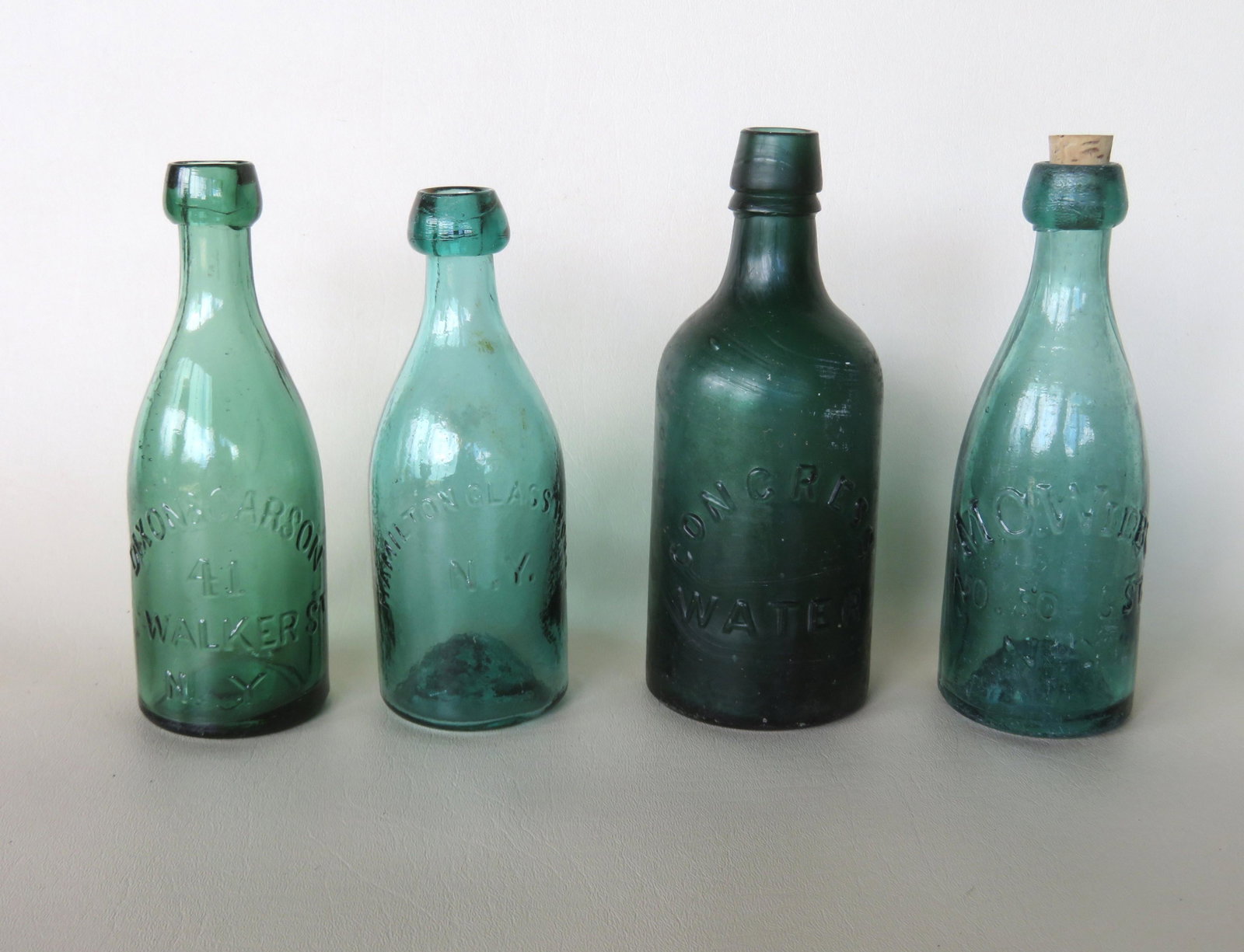 Grouping of 4 NY water/soda bottles including: Embossed: Grouping of 4 NY water/soda bottles including: Embossed mark of "CONGRESS WATER" on one side and "CONGRESS & EMPIRE SPRING CO. / SARATOGA NY" on the other side, dark green, applied sloping mouth with 