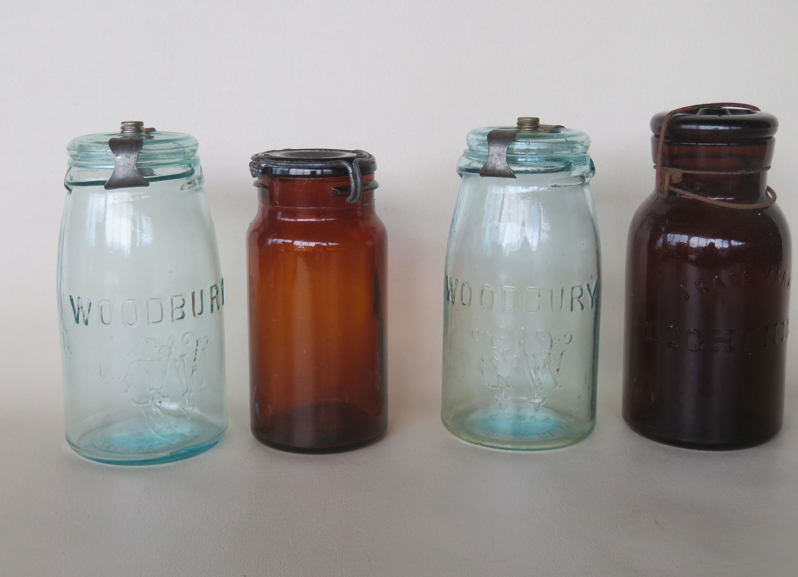 Four fruit jars including: Amber with lid signed "Geo.: Four fruit jars including: Amber with lid signed "Geo. W. Helme Co. Of New Jersey / Patented July 16 1872" and base signed "P. Lorillard Co" - 6 5/8"H; amber marked across the front "Trade Mark Lightn