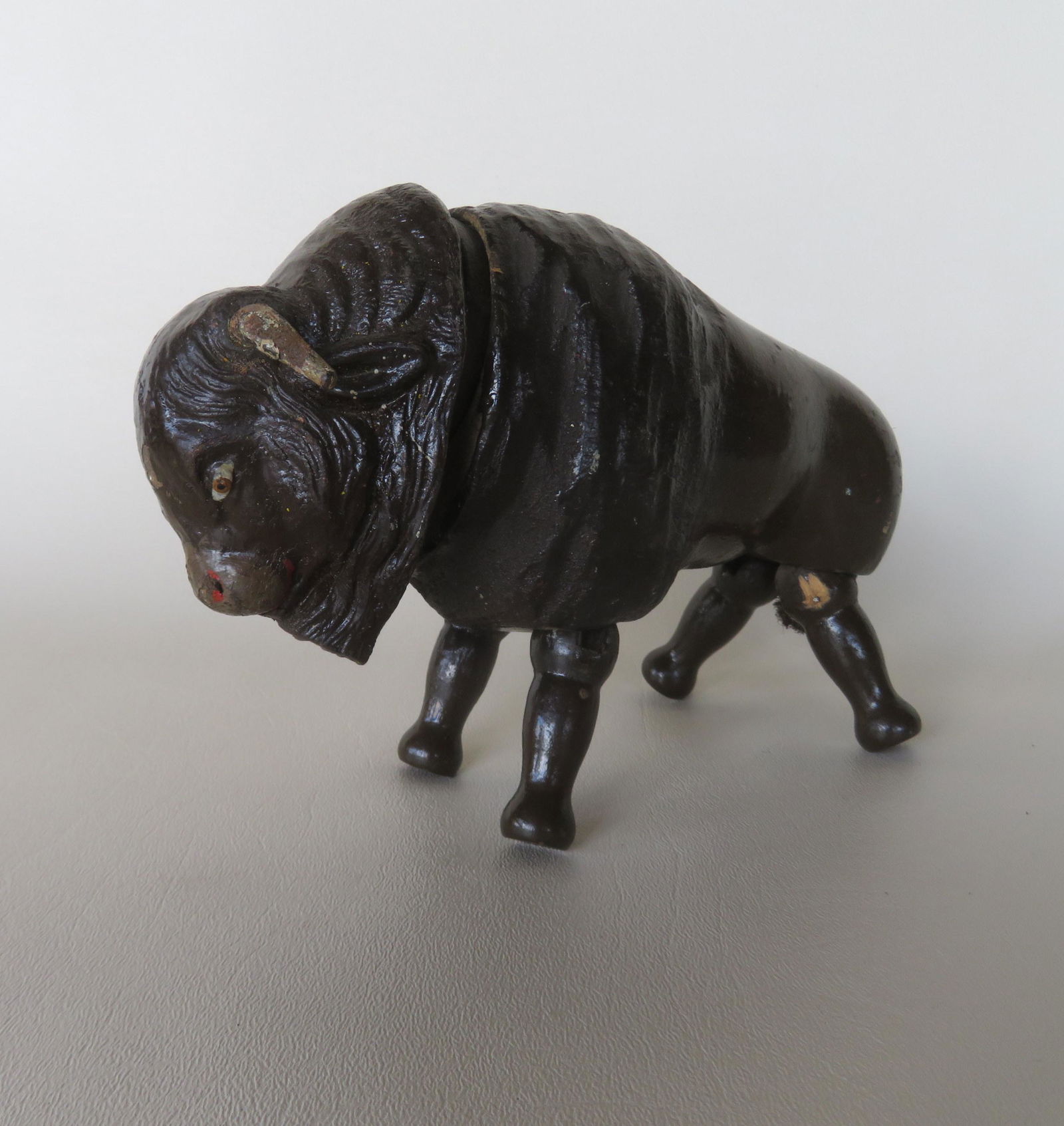 Schoenhut wooden articulated buffalo in original brown: Schoenhut wooden articulated buffalo in original brown paint and with original wooden horns and rope tail, from the Schoenhut Circus, early 20th century. 8"L x 5"H. Minor use wear, and in good origina