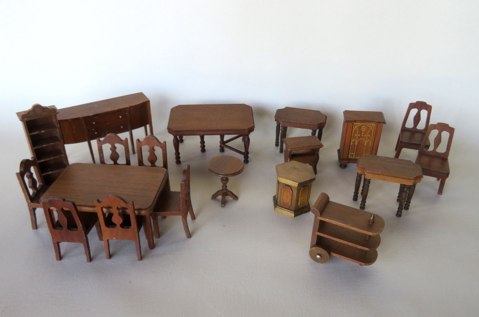 Grouping of 17 pieces of StromBecker dollhouse: Grouping of 17 pieces of StromBecker dollhouse furniture, most marked "StromBecker Playthings / Genuine Walnut / Made in USA". One dining room table missing one small cross stretches, minor use wear,