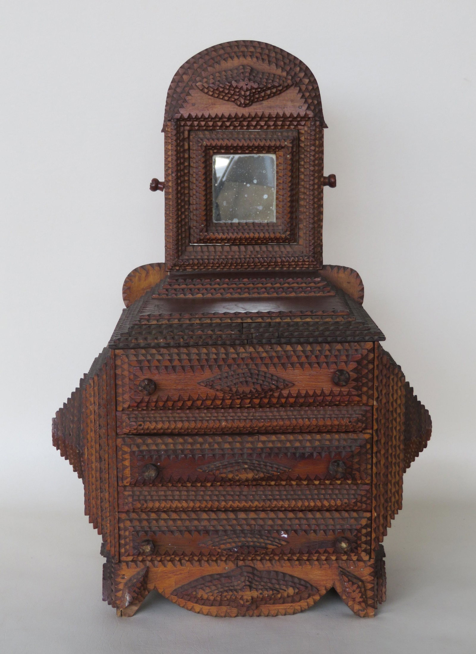 A good tramp art child size chest of 3 drawers.: A good tramp art child size chest of 3 drawers with attached swivel mirror with matching crest and matching shaped base - note the original carved wooden pulls. All 3 drawers with NY State tax stamp o