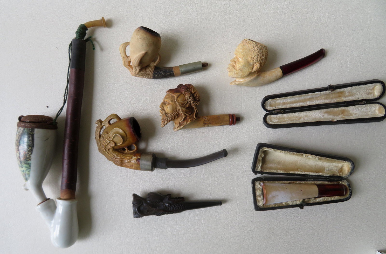 A grouping of 7 smoke related collectibles including:: A grouping of 7 smoke related collectibles including: 1) Carved clay pipe of bearded man - no stem - good condition - 3 1/2"L x 2"H; 2) White clay pipe of an African American man - 4 1/4"L x 2"H - sma