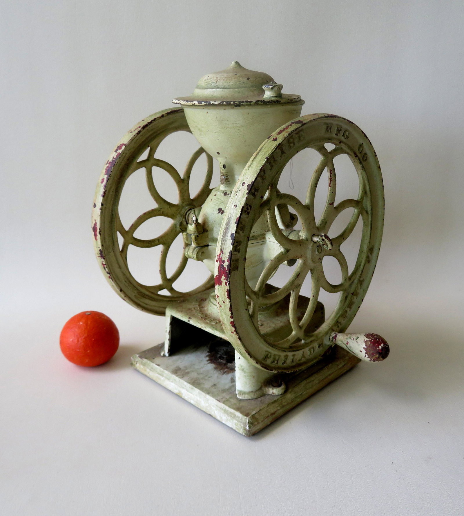 An Enterprise double wheel coffee mill with slide lid: An Enterprise double wheel coffee mill with slide lid top, signed "Enterprise Mfg. Co. / Philadelphia Pa." - Patent Oct. 21, 1875. Missing drawer, old white paint over original paint, wheels turn free