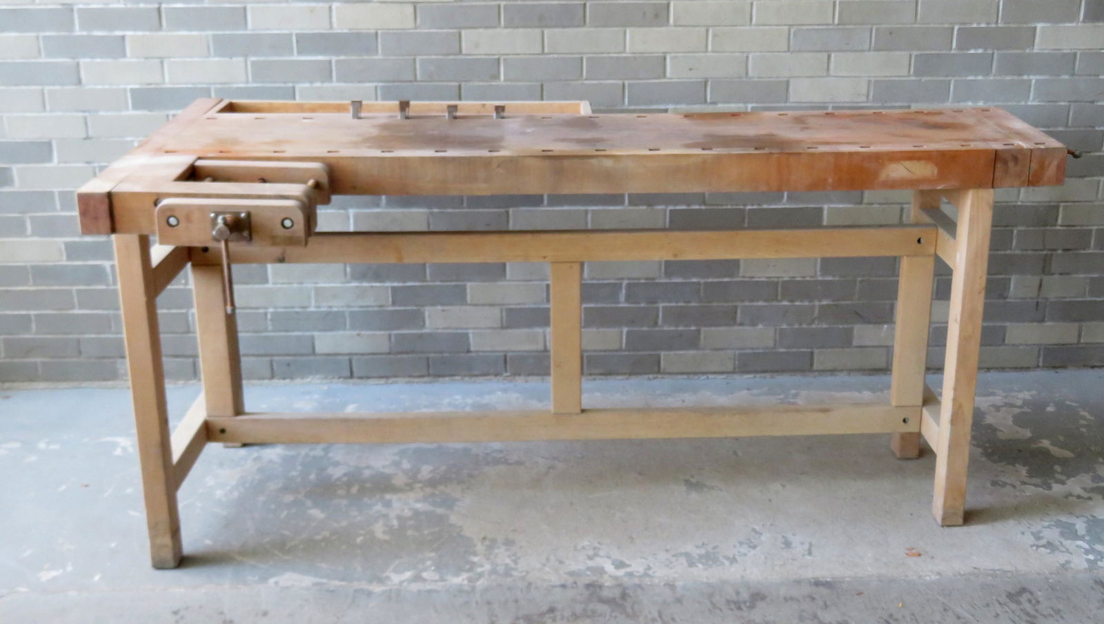 A modern carpenter's wooden work bench having an: A modern carpenter's wooden work bench having an attached vise, and 4 metal lumber stops, made in Denmark by Lervad. The top is removable from base - the total size 38"W x 72"L x 32 1/2"H. Good condit