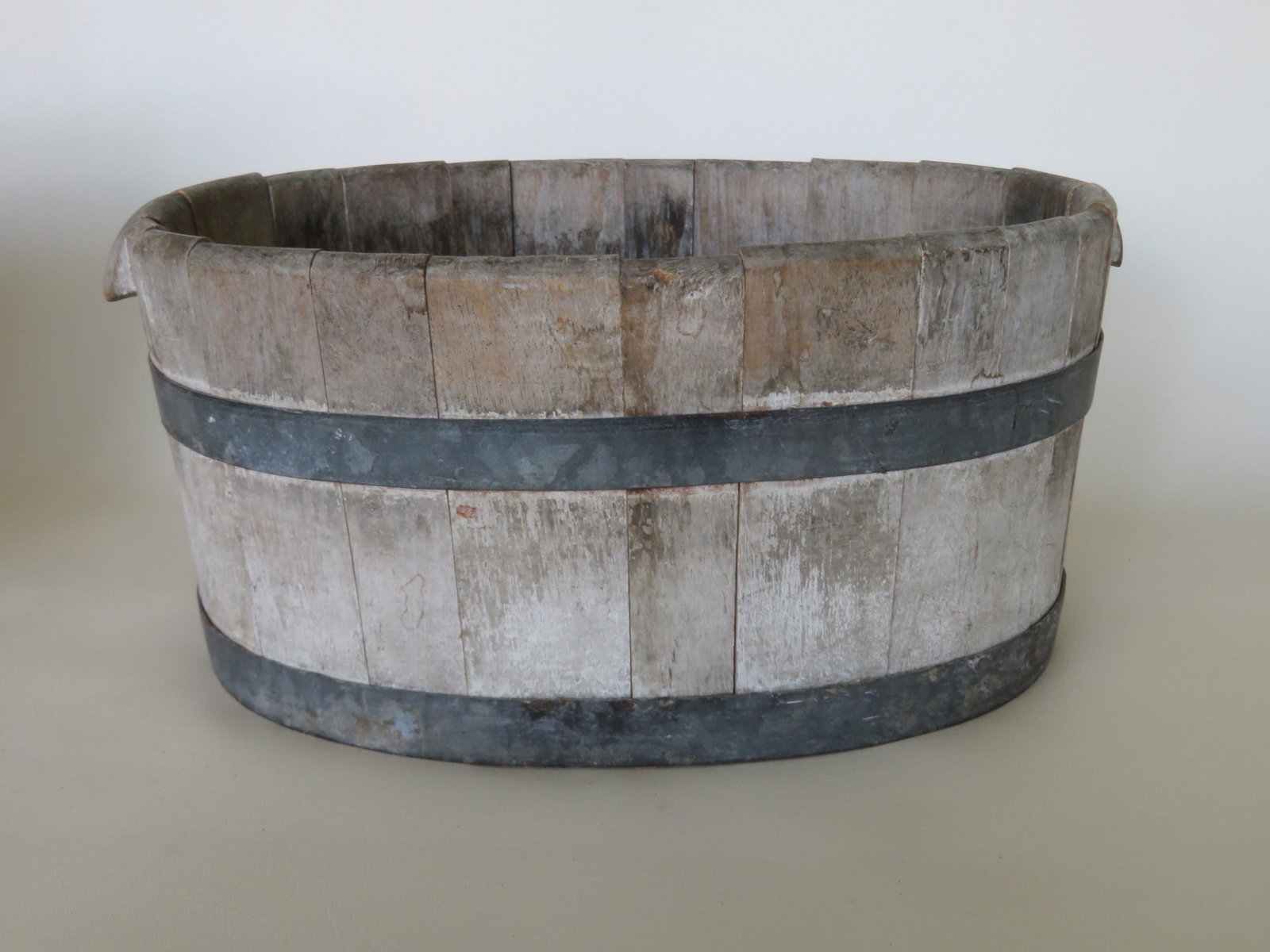 A wooden wine cooler with carved wooden handles, stave: A wooden wine cooler with carved wooden handles, stave construction, and traces of old white paint, 18th/19th century - very good condition - 17 1/2"L x 12 1/2"W x 7 1/2"H. Provenance: From a retired 