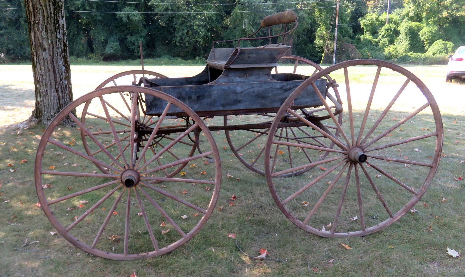 A vintage 1 seat buggy with wooden wheels and shaft.: A vintage 1 seat buggy with wooden wheels and shaft. Total size 5' x 8'. Metal label attached to rear that reads "John V. Miller Andes (?) NY". The cab in original blue paint - the wheels with traces 