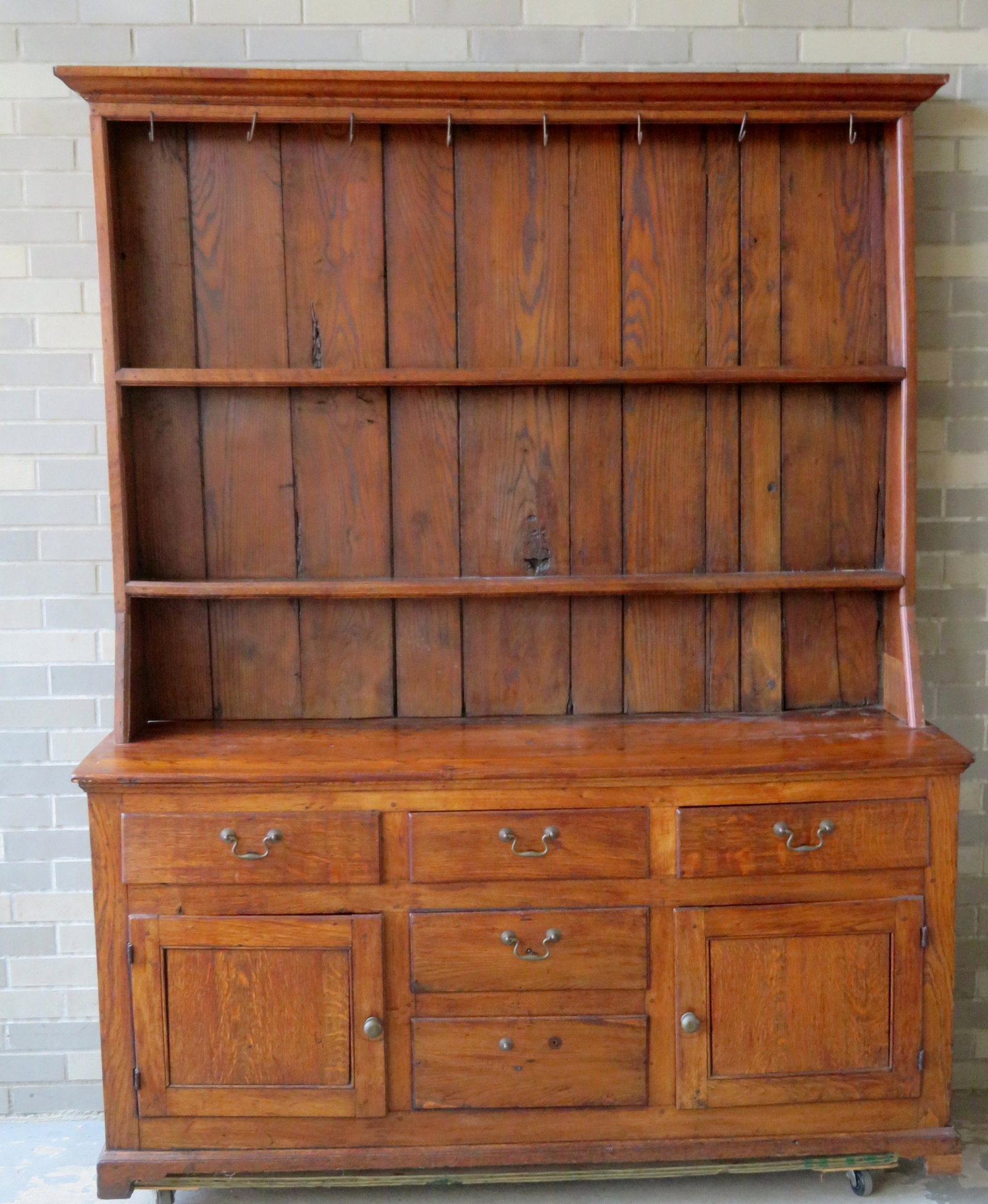 A Chippendale 2 part pewter cupboard with restoration,: A Chippendale 2 part pewter cupboard with restoration, Irish or English, late 18th century with some 19th century replaced parts. The open top has 2 shelves over a base with 3 short drawers over 2 fal