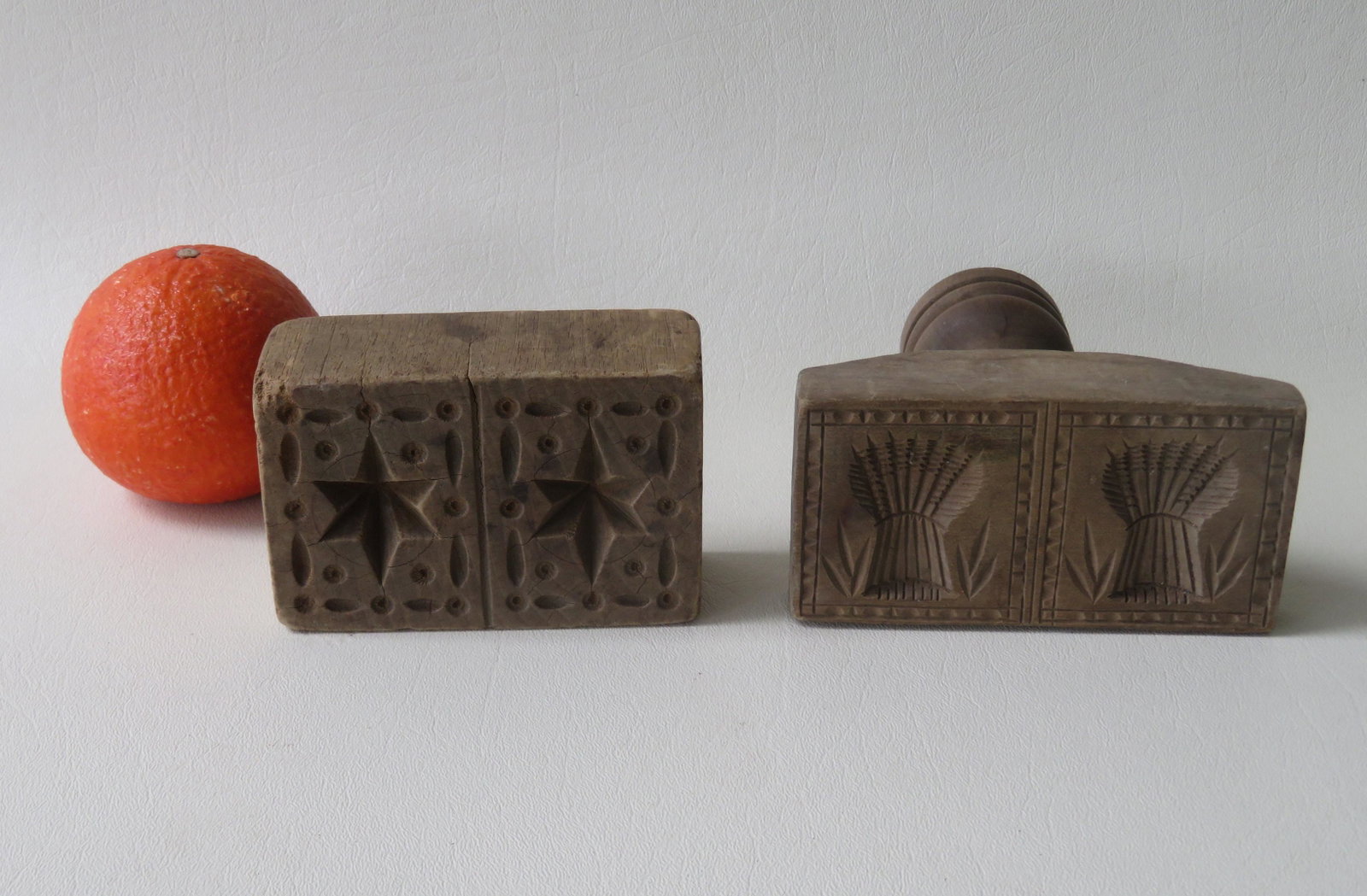 Two early wooden butter stamps including one with: Two early wooden butter stamps including one with double stars signed J.O. Amos, and the other with sheaf of wheat pattern, mid 19th century. The largest with handle measures 4 7/8"L x 2 3/8"W x 5 1/8