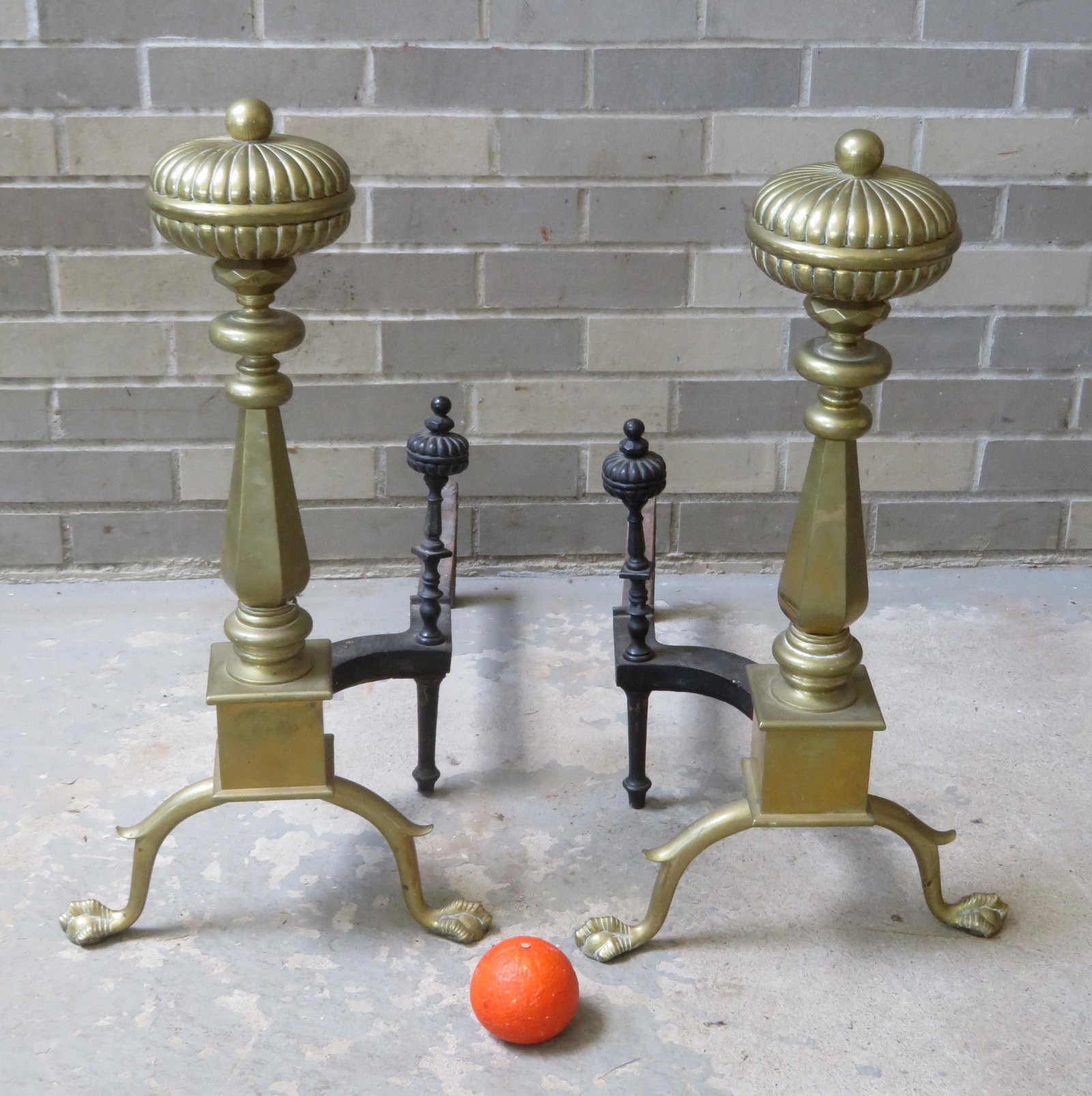 A massive pair of Chippendale style brass andirons with: A massive pair of Chippendale style brass andirons with a gadrooned top over multi-faceted oval, over hexagonal and turned column mounted on square plinth with spurred legs leading to claw and ball fe