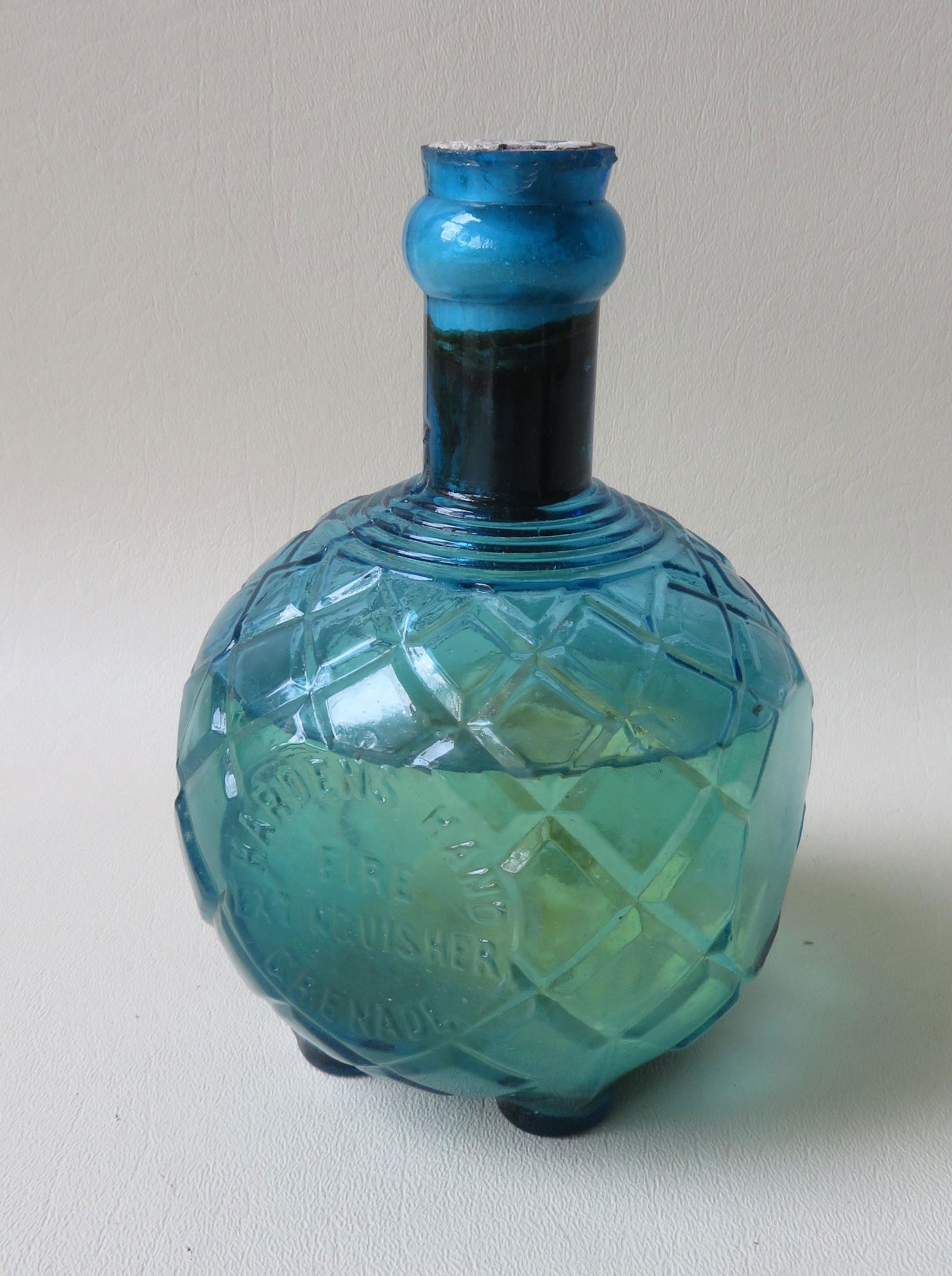 Glass fire extinguisher marked "HARDENS HAND GRANADE /: Glass fire extinguisher marked "HARDENS HAND GRANADE / FIRE EXTINGUISHER" on front side and reverse panel marked "PATENTED NO. 1 / AUG. 8 1871 / AUG 14 1883". The footed bottle with cross hatching, is