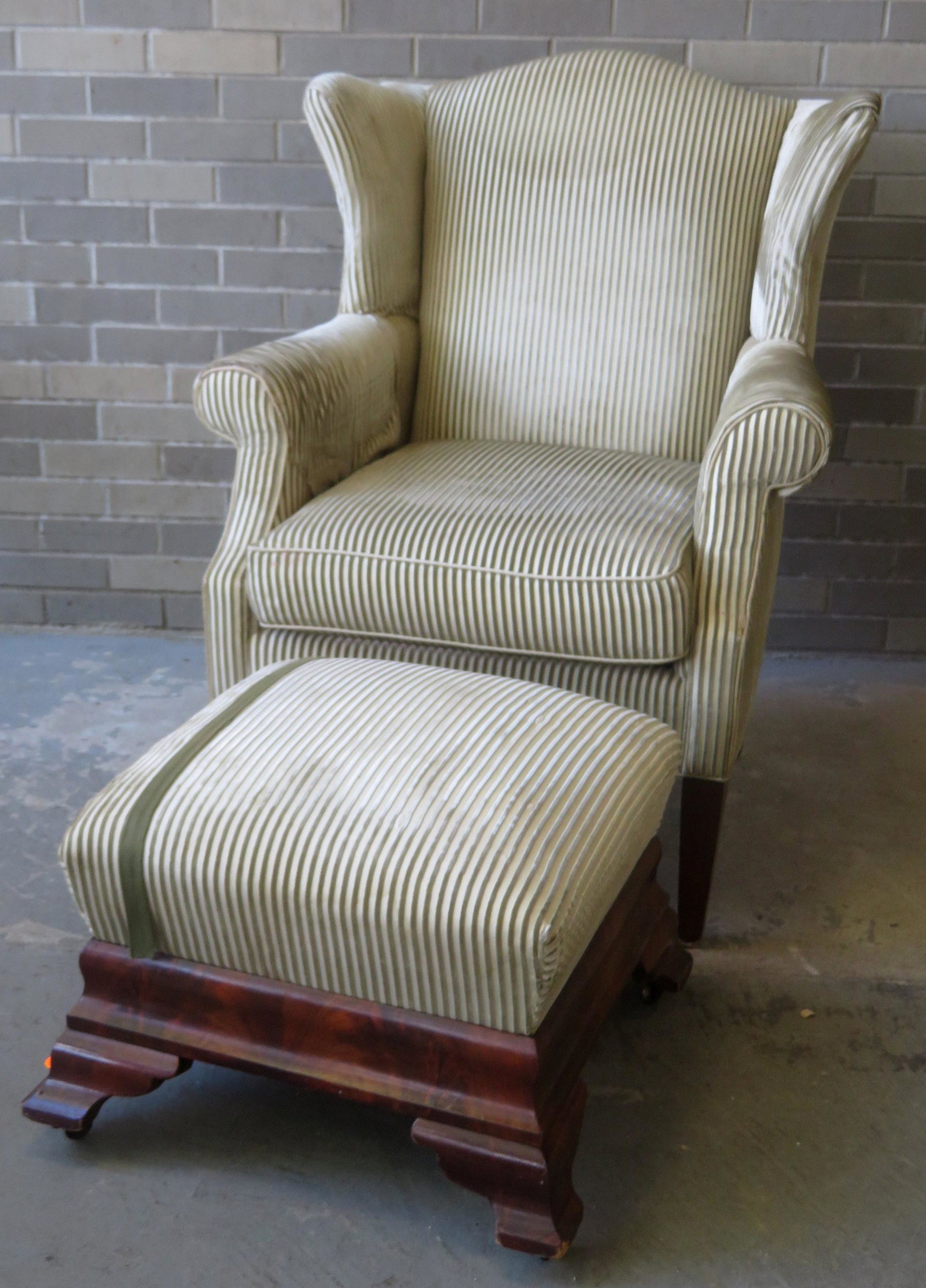 Hepplewhite style upholstered wing chair - 40"H x 31"W: Hepplewhite style upholstered wing chair - 40"H x 31"W x 24"D , probably 20th century; combined with an Empire period footstool in matching upholstery - 22" square x 14"H. The chair with wear to seat 