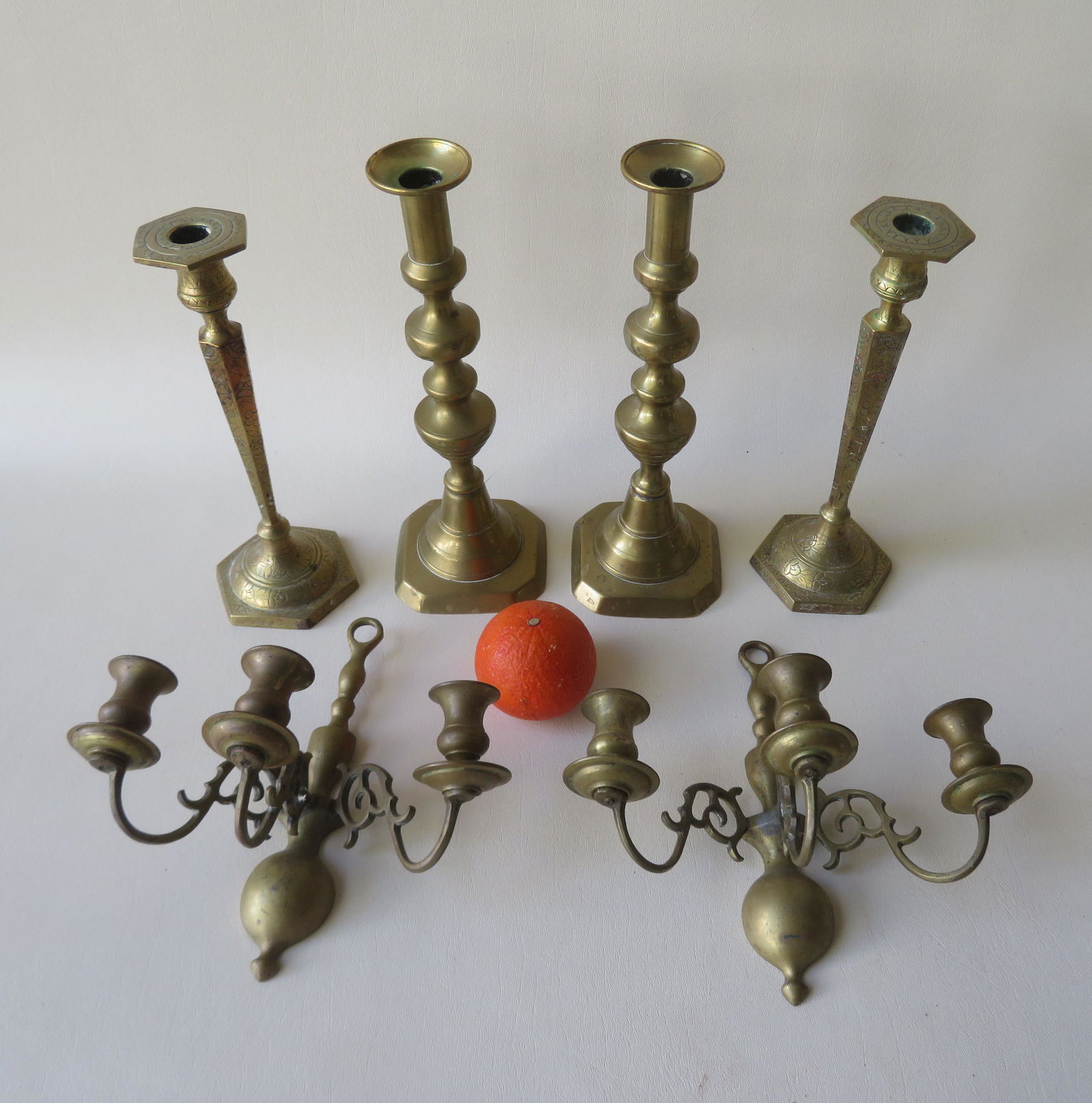 Grouping of 3 pairs of brass lighting devices including: Grouping of 3 pairs of brass lighting devices including pair of wall hanging candelabras with 3 lights, pair of pushup candlesticks, and an pair of Persian style incised candlesticks. The oldest and l