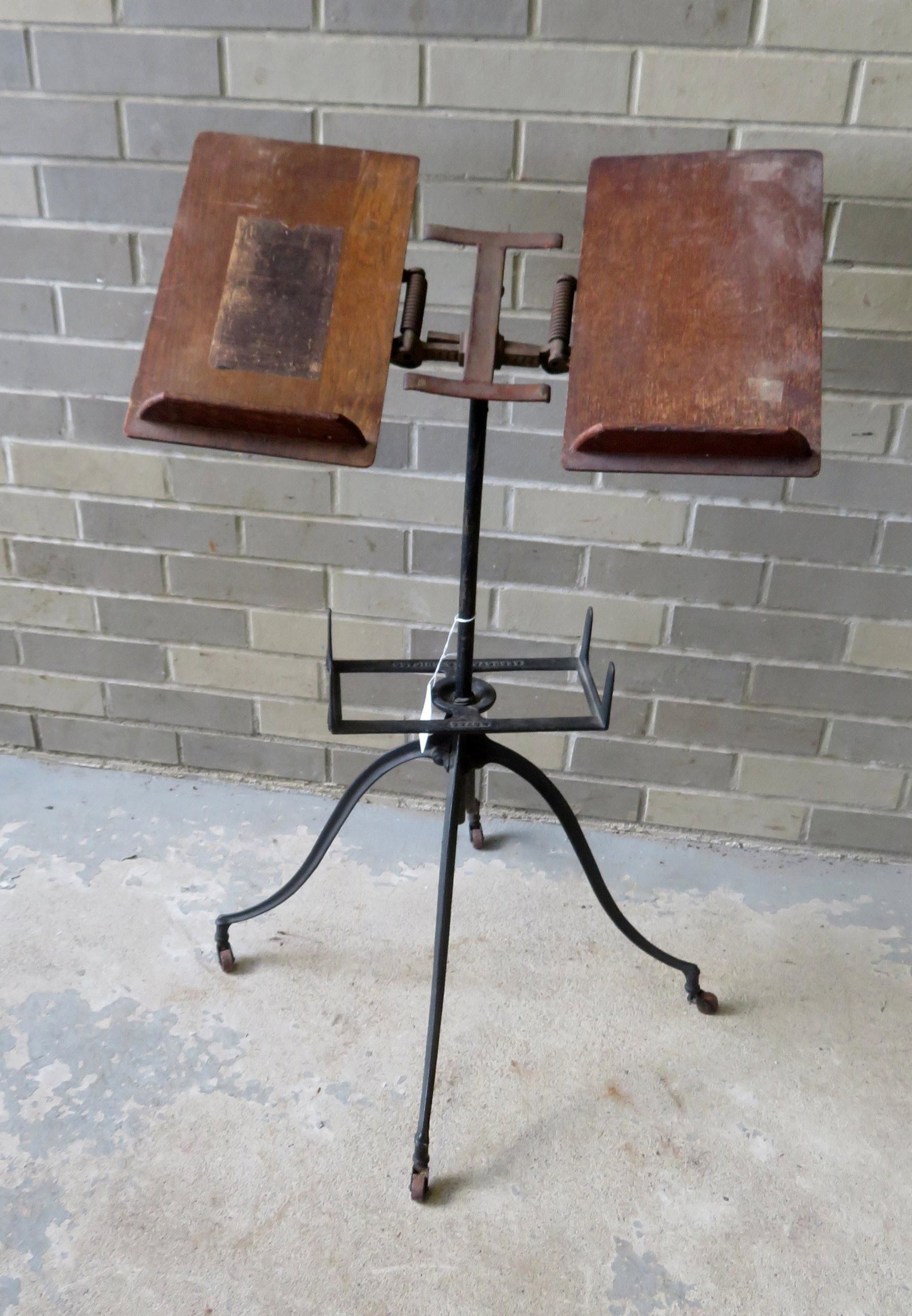Oak and iron adjustable bookstand on wheels signed: Oak and iron adjustable bookstand on wheels signed Noyes 6 - Aermotor Co. Chicago, very good condition, early 20th century. 22 1/2"W (at base) x 36"H. Provenance: From the Stanley Blum estate, Rhinebe