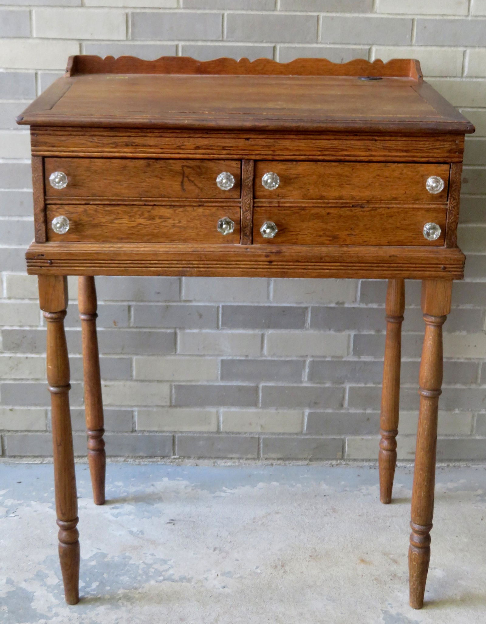 Oak floor standing 4 drawer desk in the form of a spool: Oak floor standing 4 drawer desk in the form of a spool cabinet on stand with turned oak legs, signed J.P. Coats, having a slanted lift top with original inkwell and pencil groove - the inkwell signed